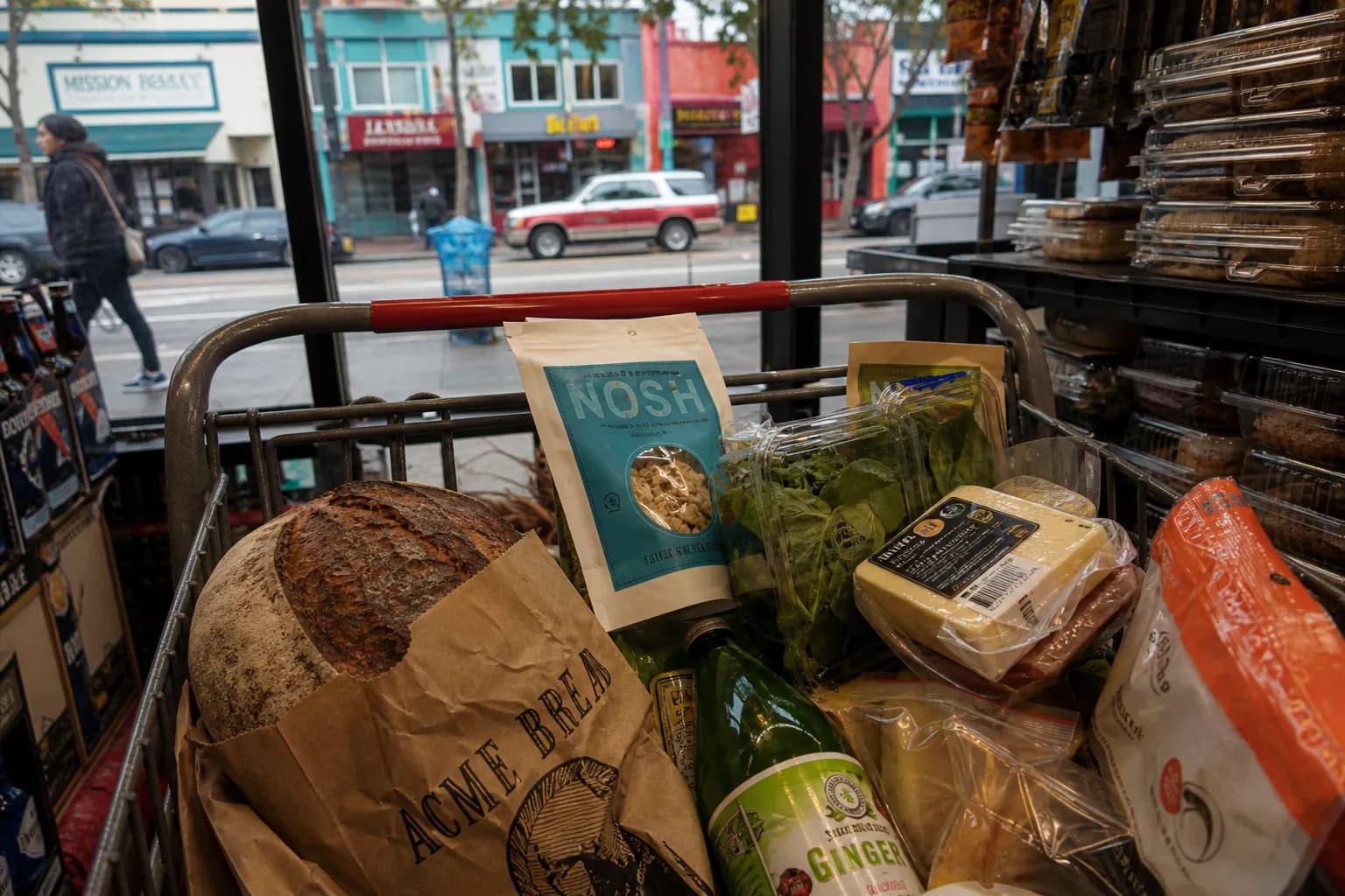 A grocery cart filled with discounted organic and specialty foods at the Mission Grocery Outlet in San Francisco