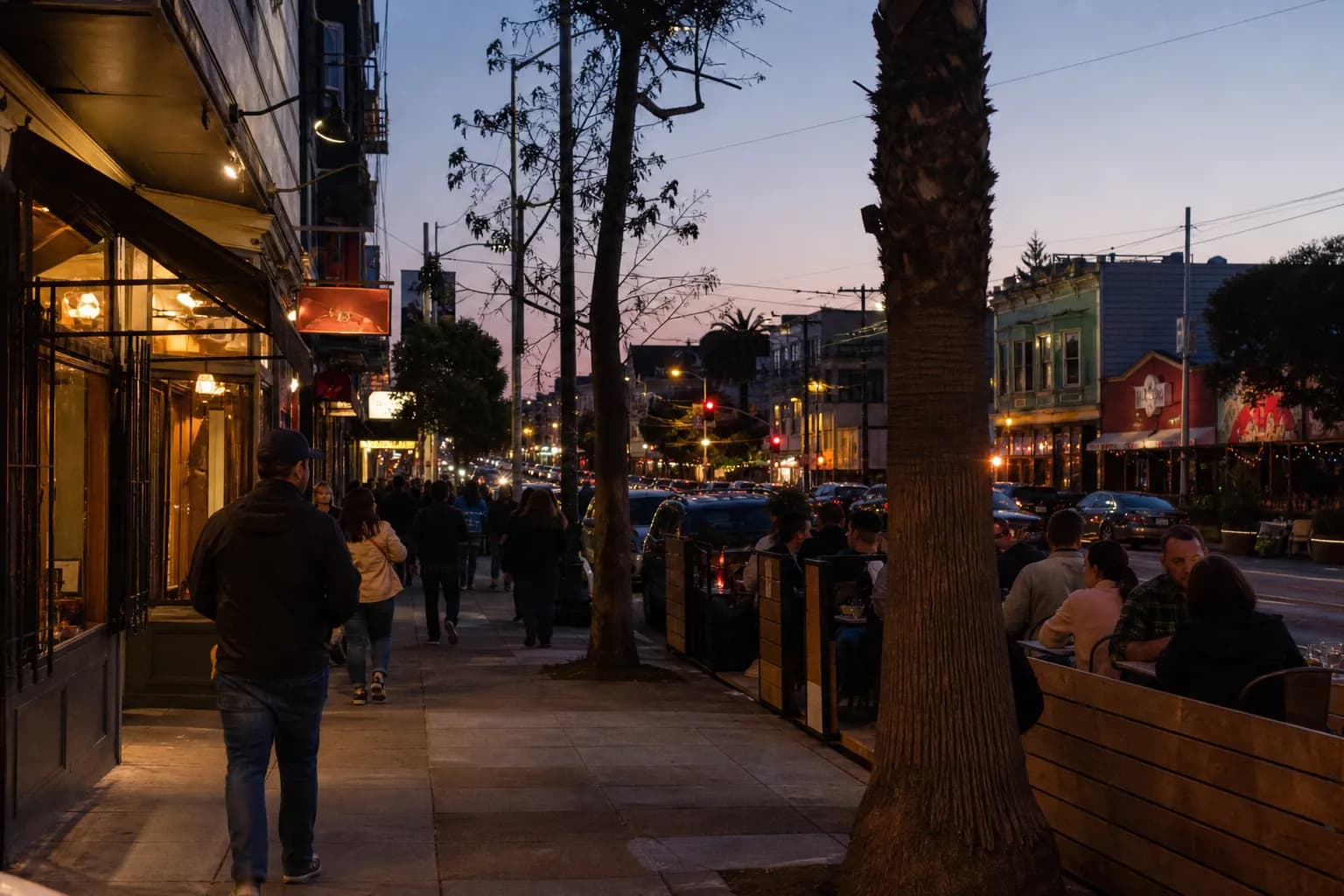 Valencia Street in San Francisco's Mission District glowing at dusk during dinner hours.