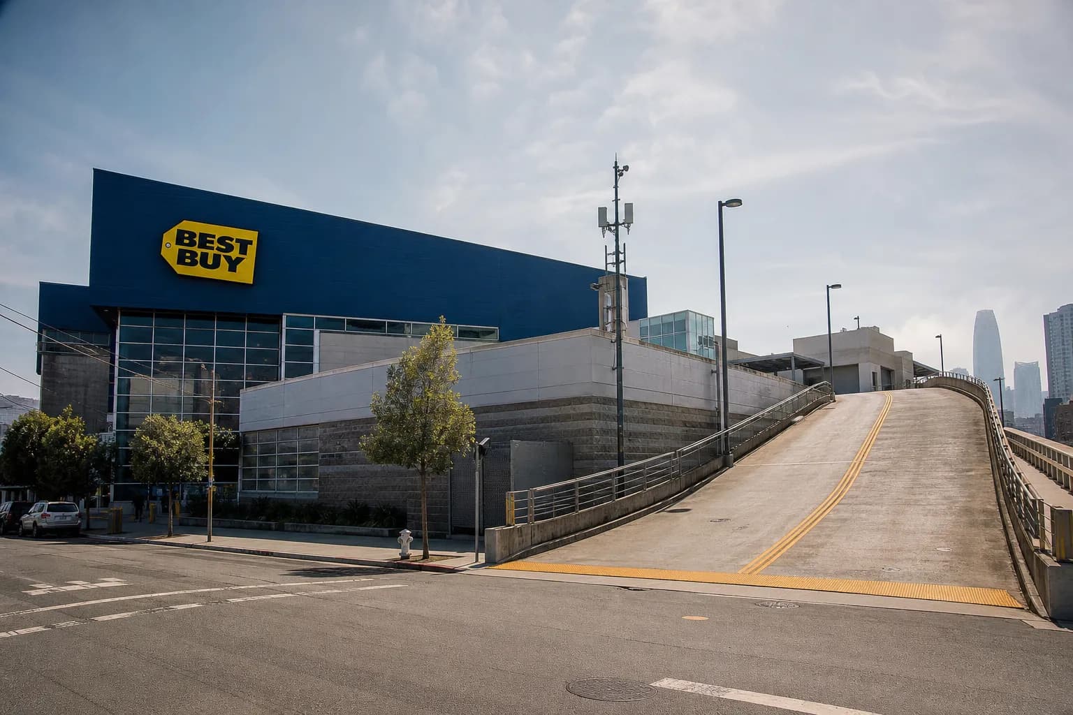 Exterior establishing shot of the SoMa San Francisco Best Buy building and its rooftop parking ramp on Harrison Street.