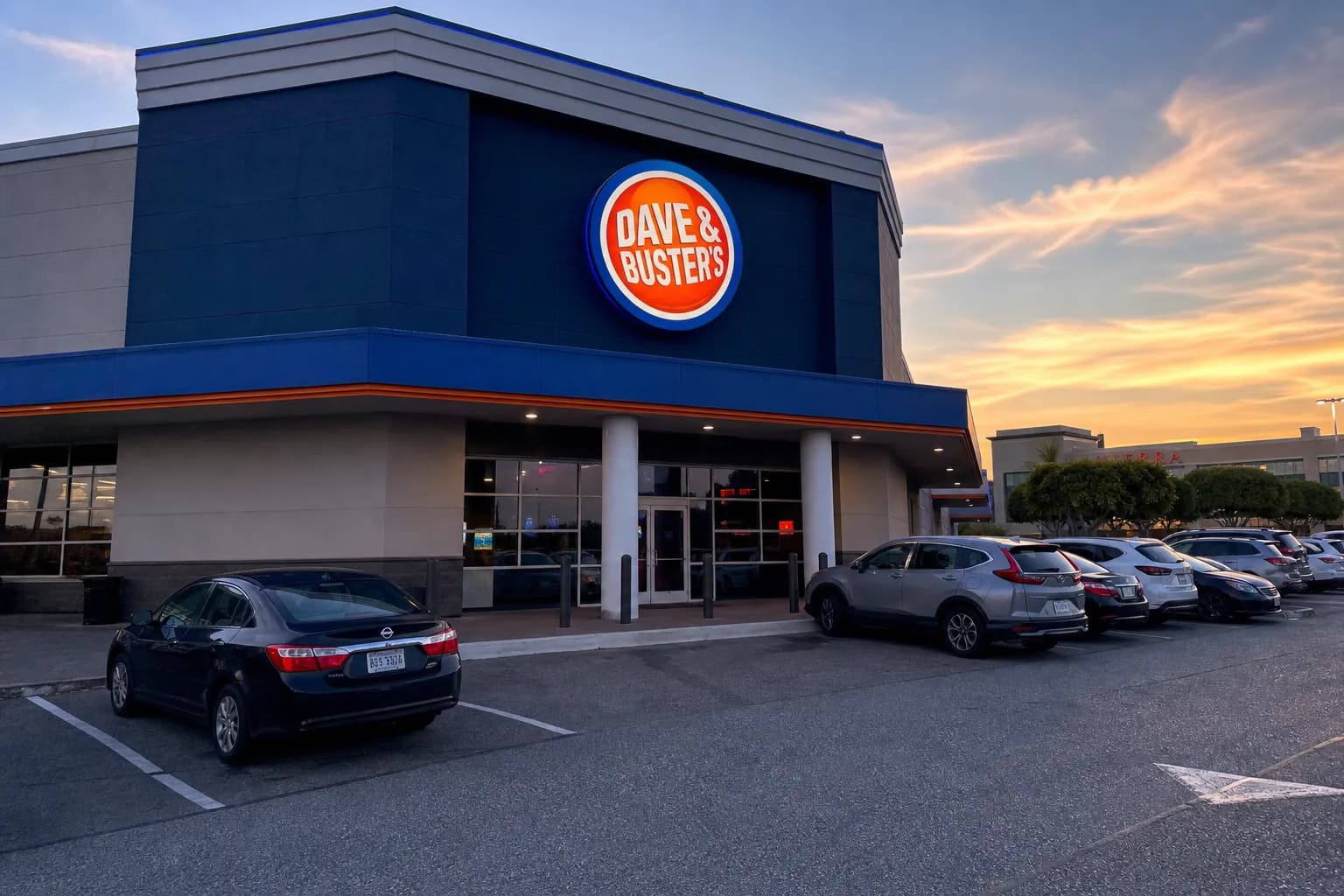The modern exterior entrance of the Daly City location lit up at dusk.