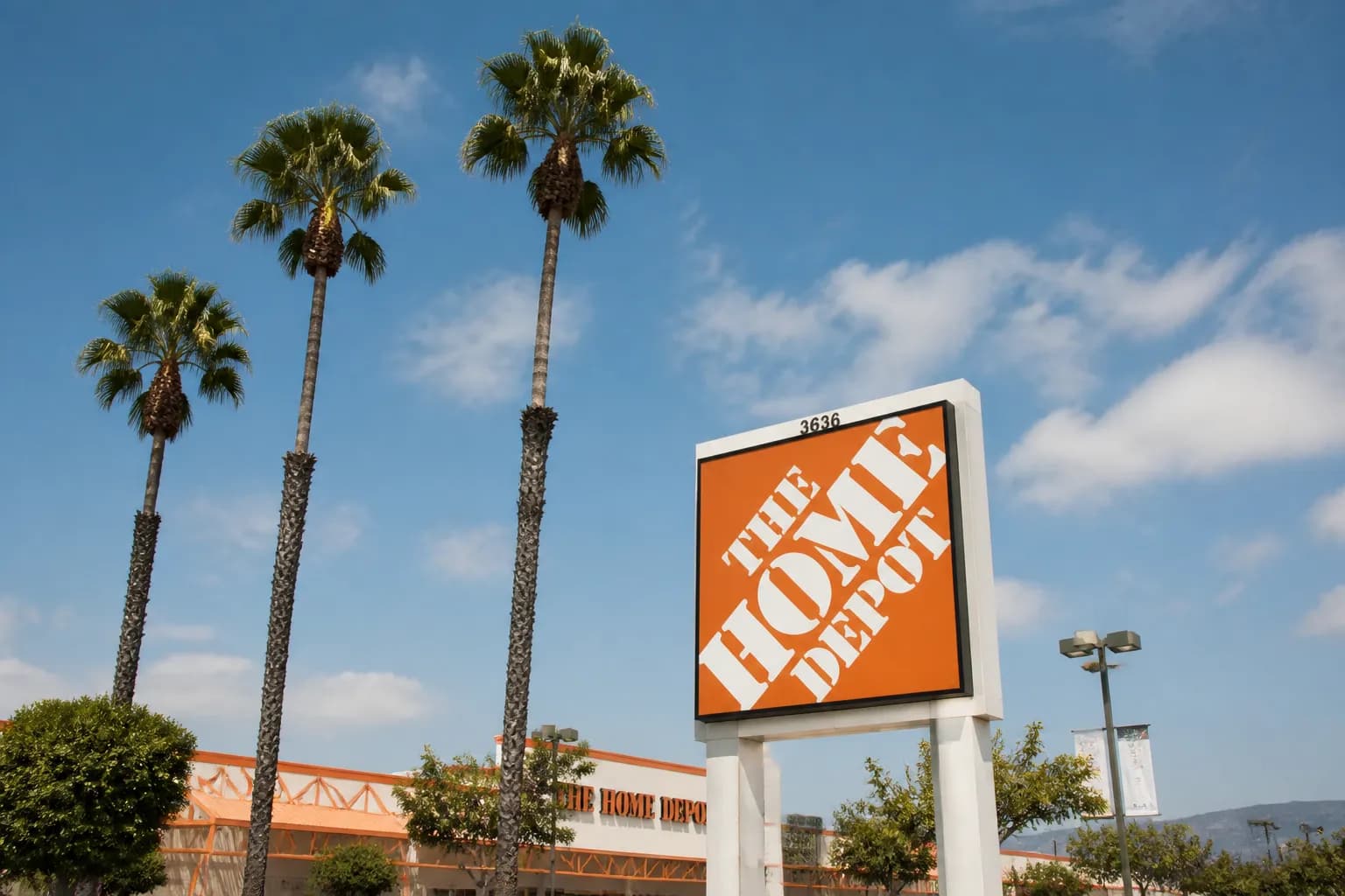 A vibrant orange Home Depot sign illuminated at dusk against the Bay Area sky.