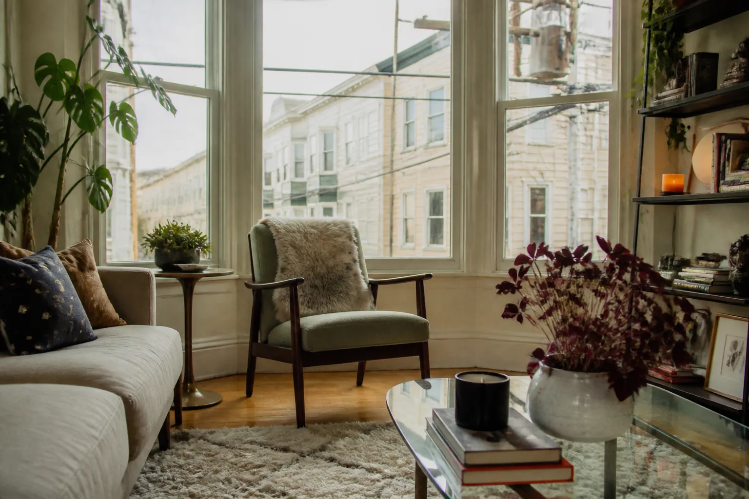 A cozy, sunlit San Francisco living room featuring mid-century modern furniture and bay windows.