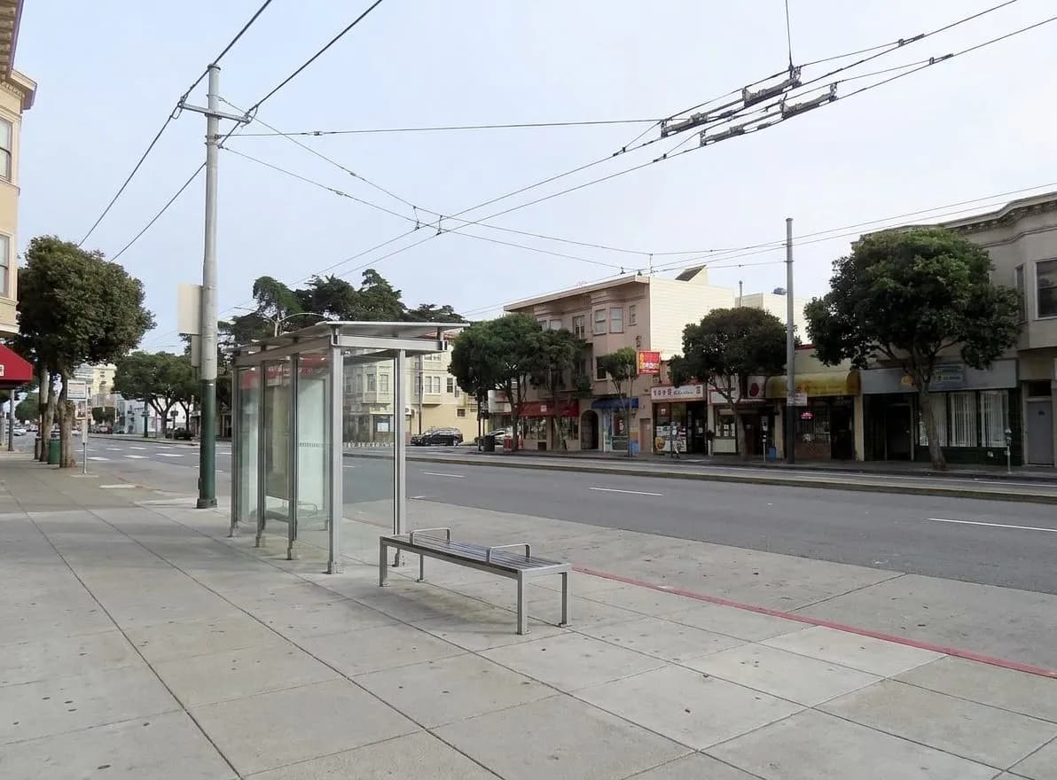 Muni bus stop on Geary Boulevard with overhead wires and sidewalk in Japantown