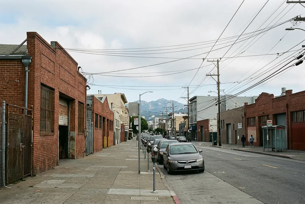 Exterior of a single-story brick building on a quiet Tenderloin street in San Francisco, once an auto body shop.