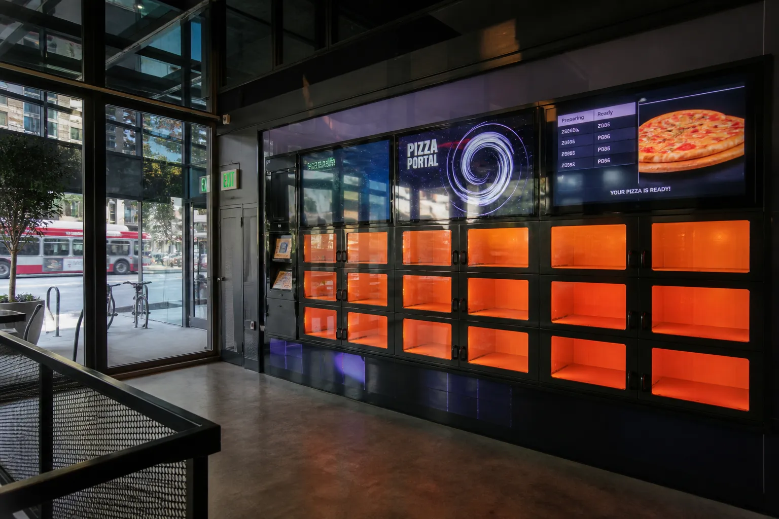 A digital self-service pizza pickup kiosk with orange heated compartments.