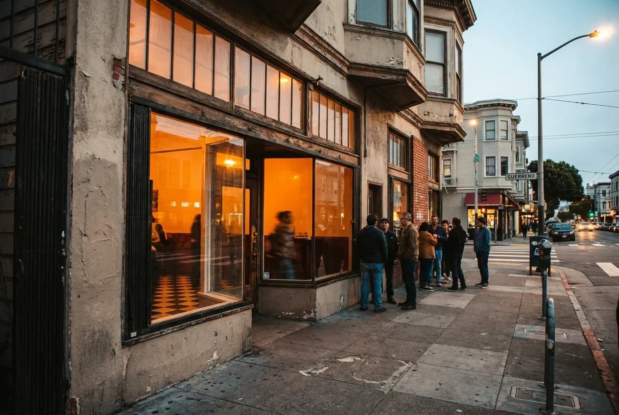 Bar Part Time storefront at 496 14th Street in Mission District at dusk with warm interior lighting and people waiting outside