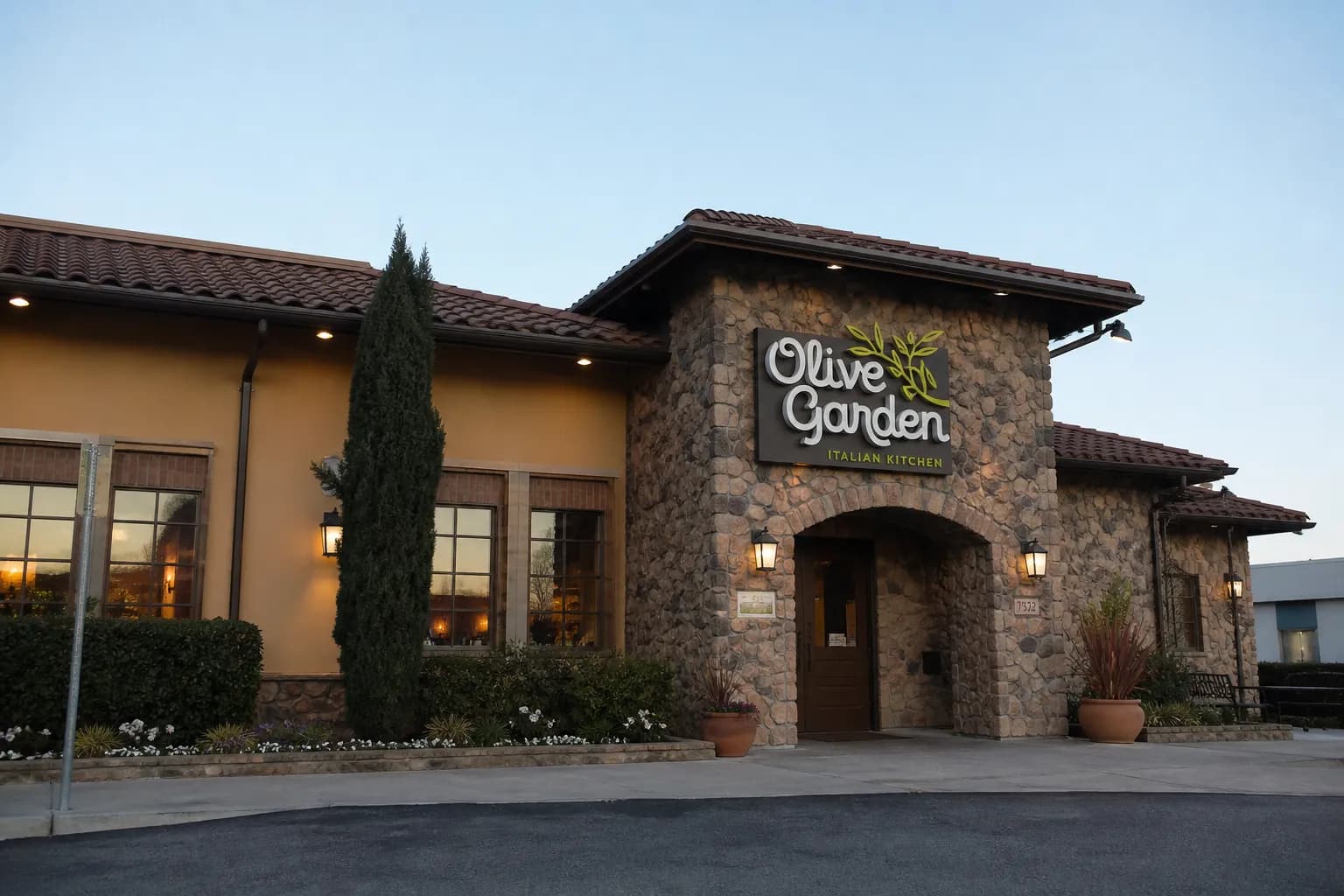 The stone-decorated exterior facade of a suburban Olive Garden location at dusk.
