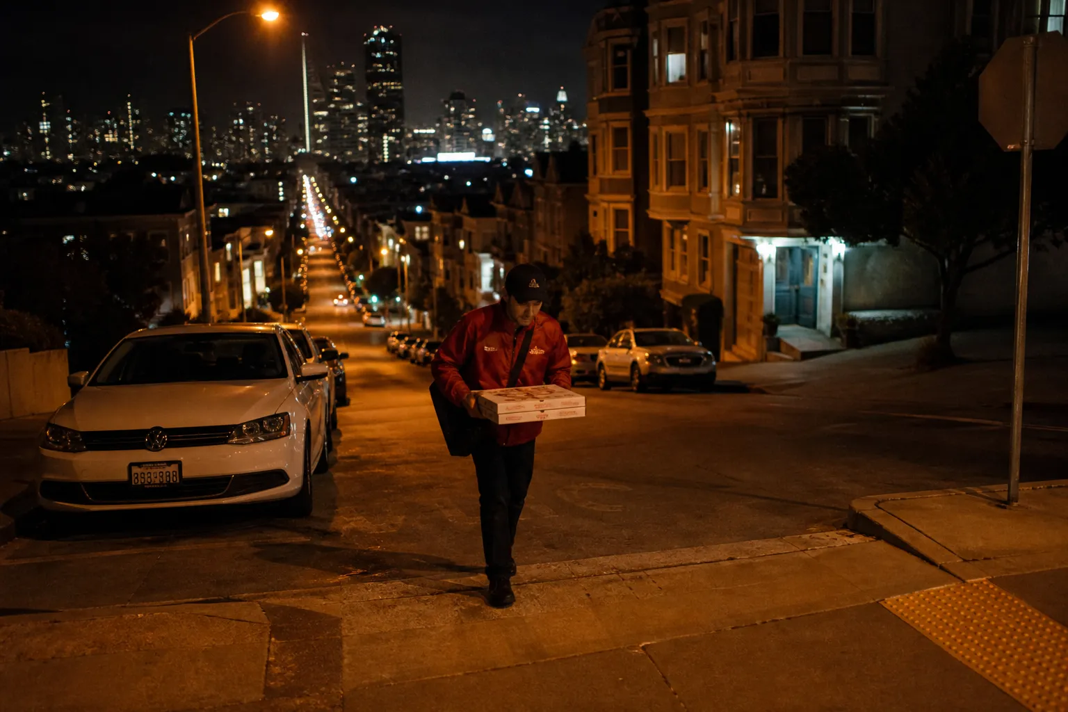 A fresh, hot Papa Johns pepperoni pizza sitting on a rustic wooden table with a side of special garlic dipping sauce, set against a softly blurred San Francisco window view at night.