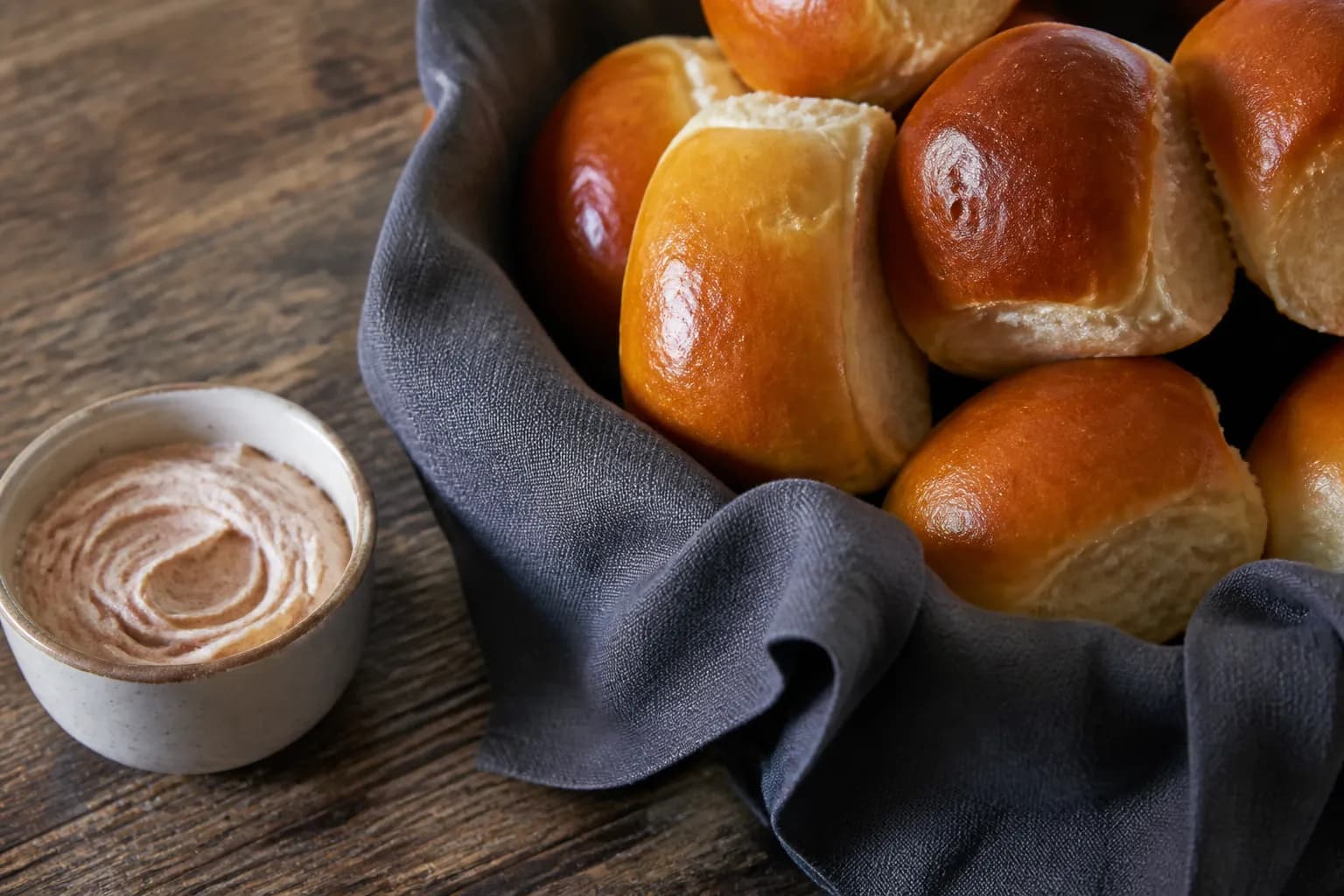 A basket of freshly baked yeast rolls with whipped cinnamon butter.