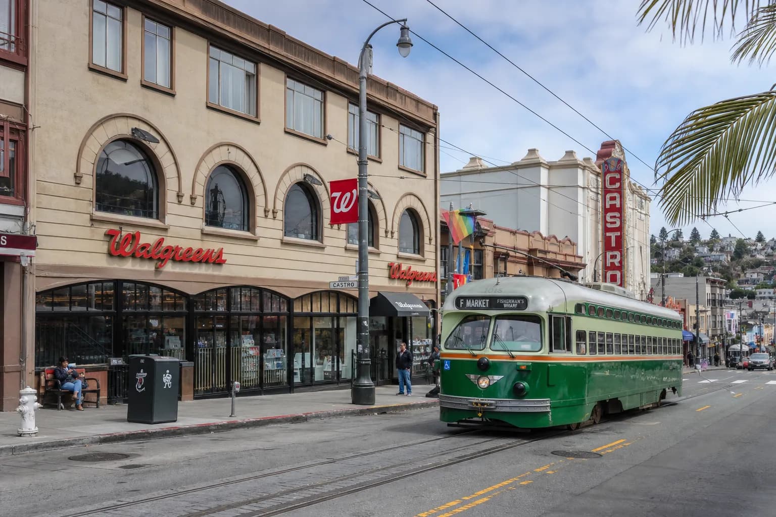 A wide angle street view of the Castro neighborhood in San Francisco with a Walgreens storefront visible near historic transit lines