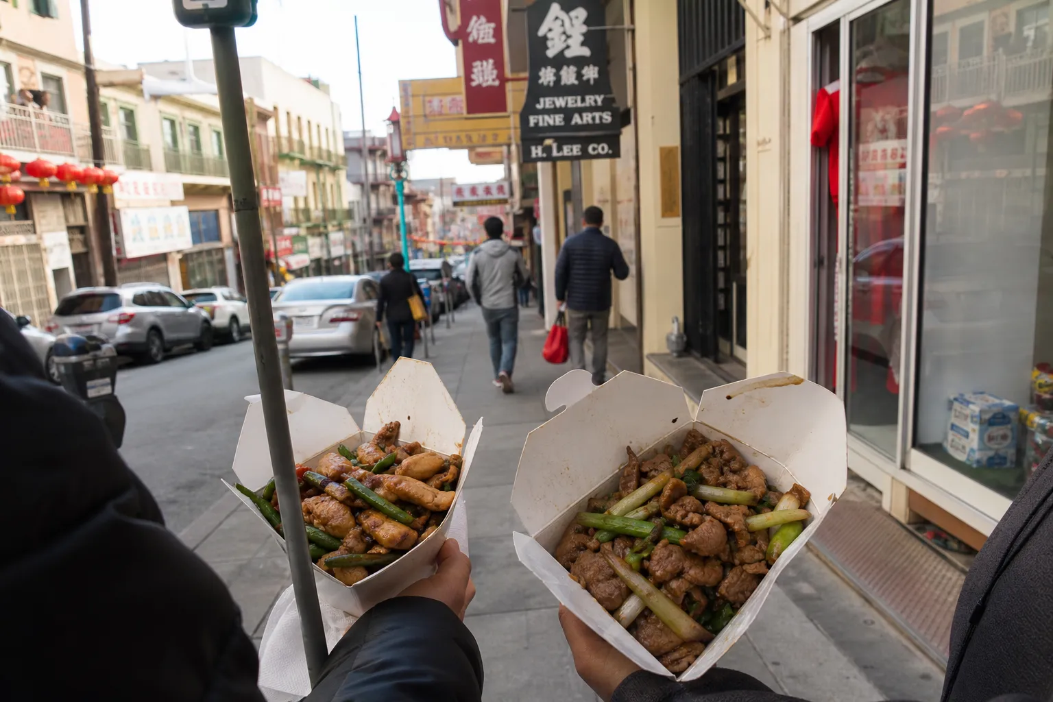 Takeout boxes of stir-fried Chinatown dishes carried past Portsmouth Square in San Francisco
