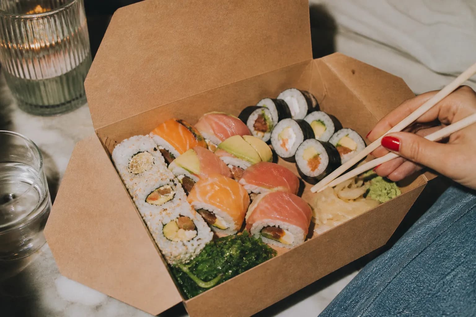 A sushi to-go box filled with an assortment of freshly made rolls