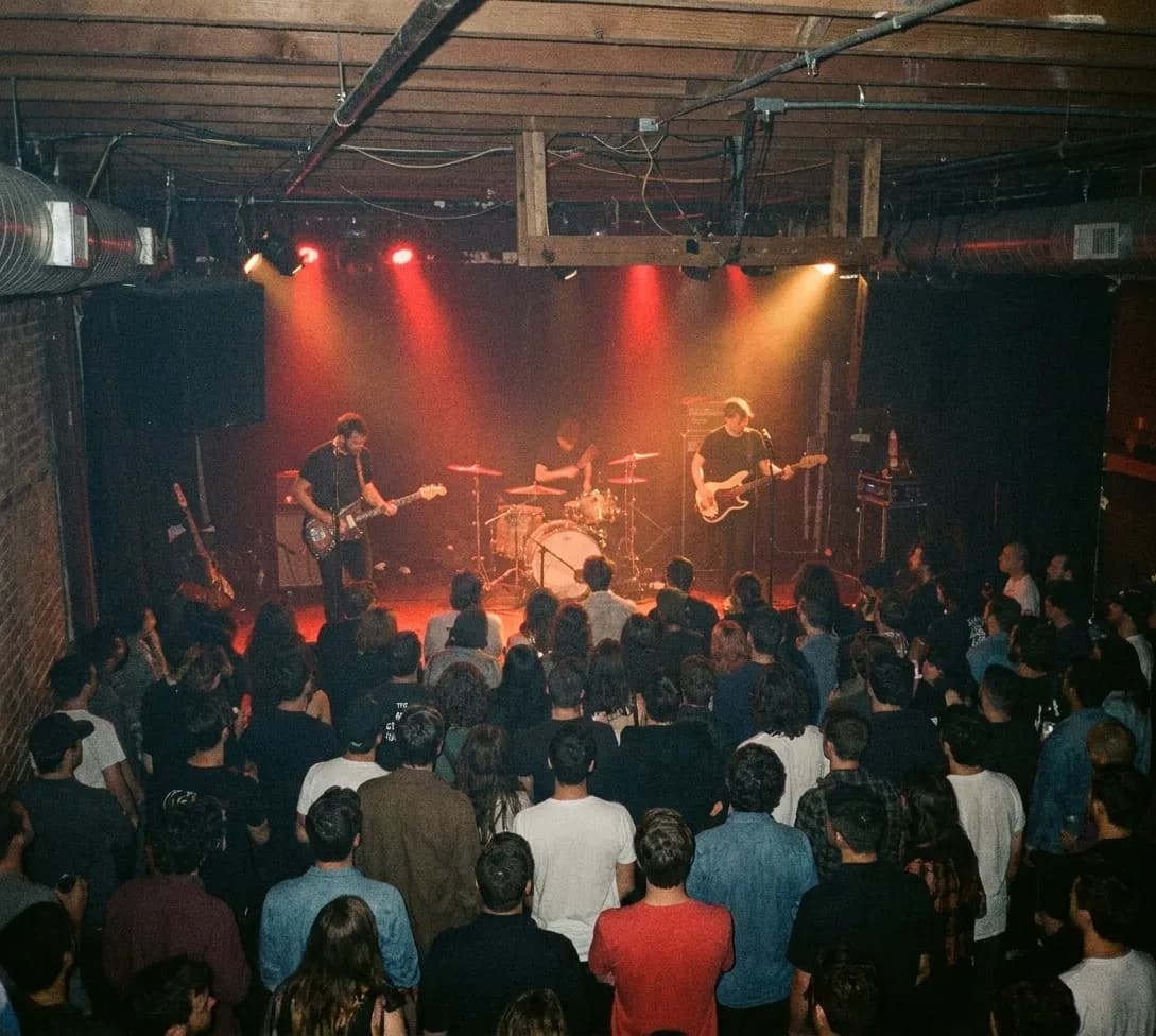 A small dark club with a low stage, a guitarist lit in red and a crowd of maybe a hundred people packed close to the front