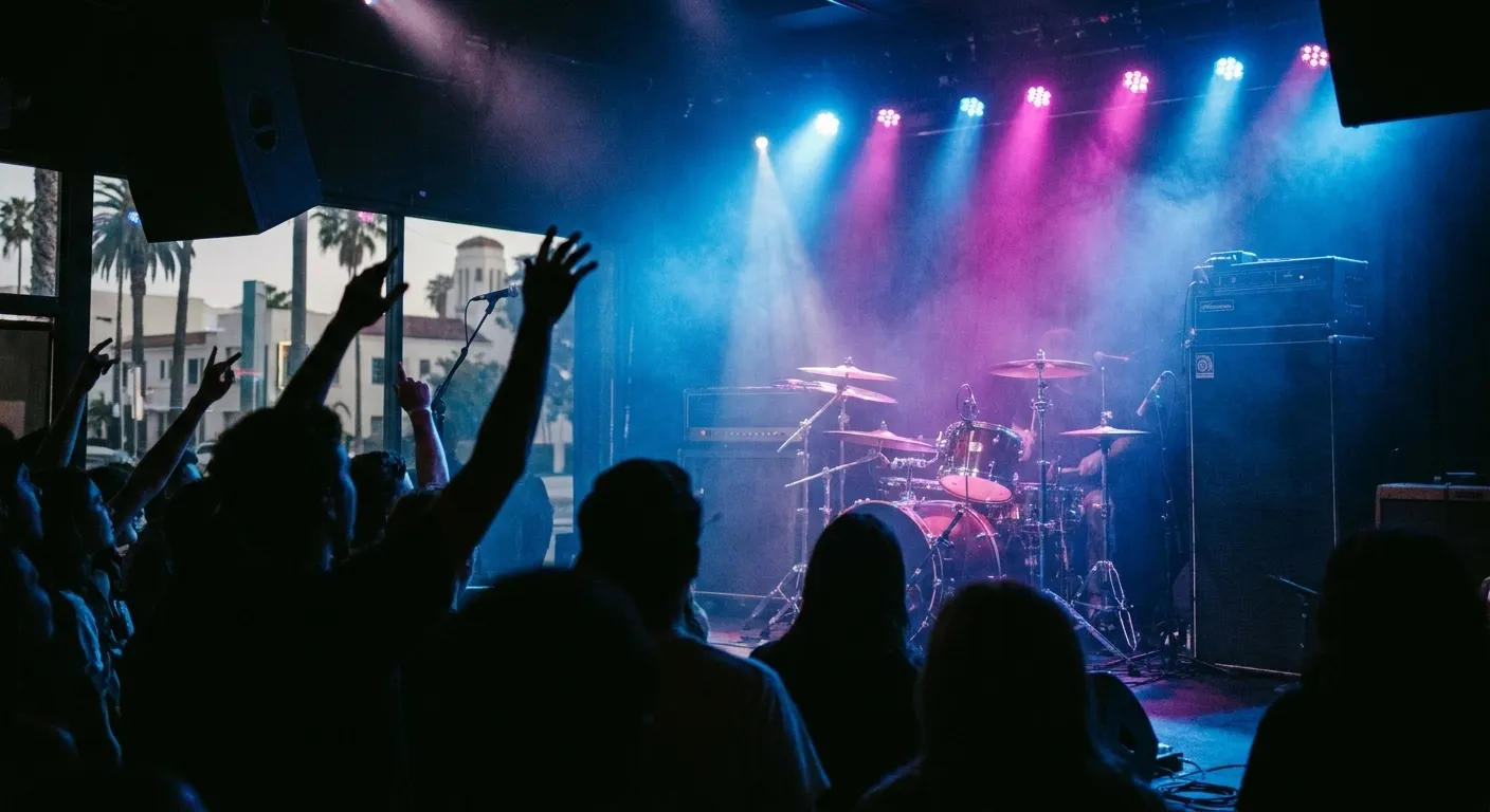 A club stage under coloured lights with a crowd silhouetted in front
