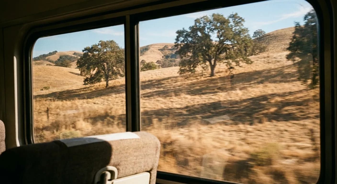 Open Northern Californian countryside seen from a moving train window in the afternoon