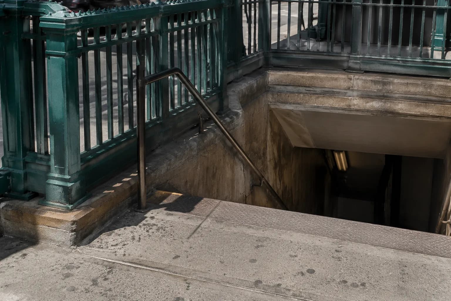 Jefferson Street L train station entrance in Bushwick with green railings and concrete steps