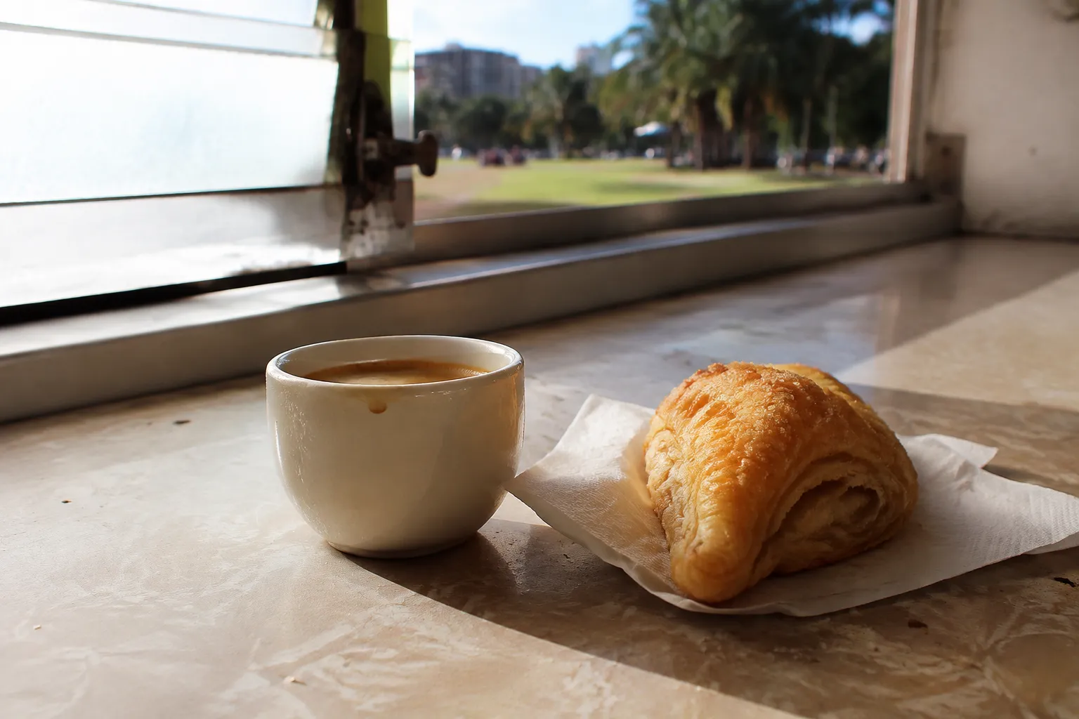 Cortadito and pastelito on a counter at a Little Havana ventanita in morning light