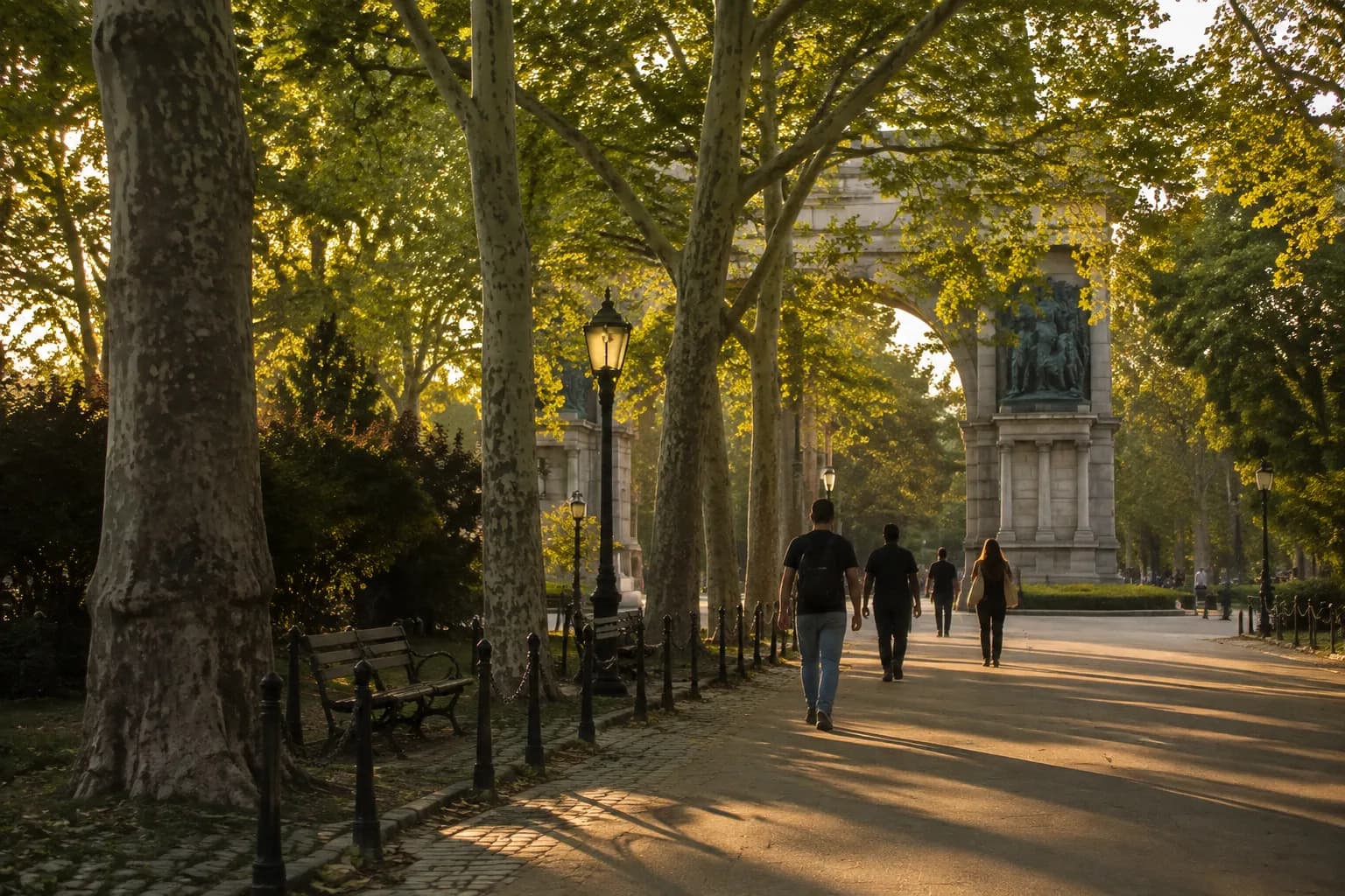 Grand Army Plaza entrance to Prospect Park in late afternoon summer light with tree-lined path
