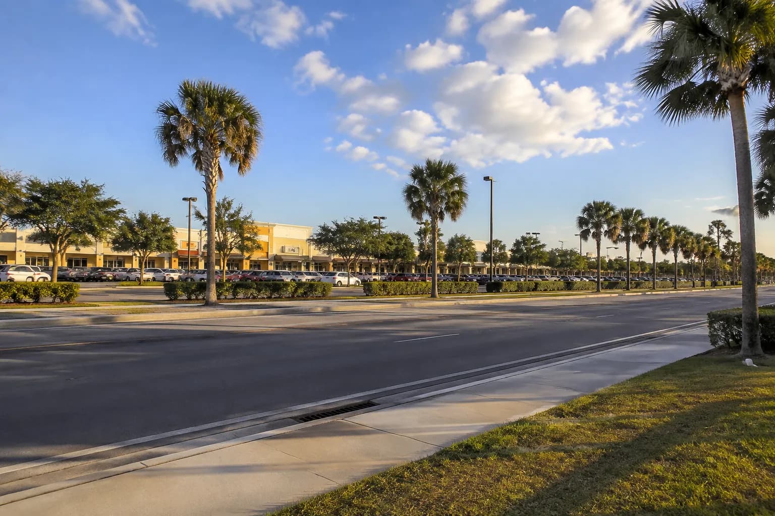 Wide commercial street view in Doral with parking lots and retail buildings under afternoon sun