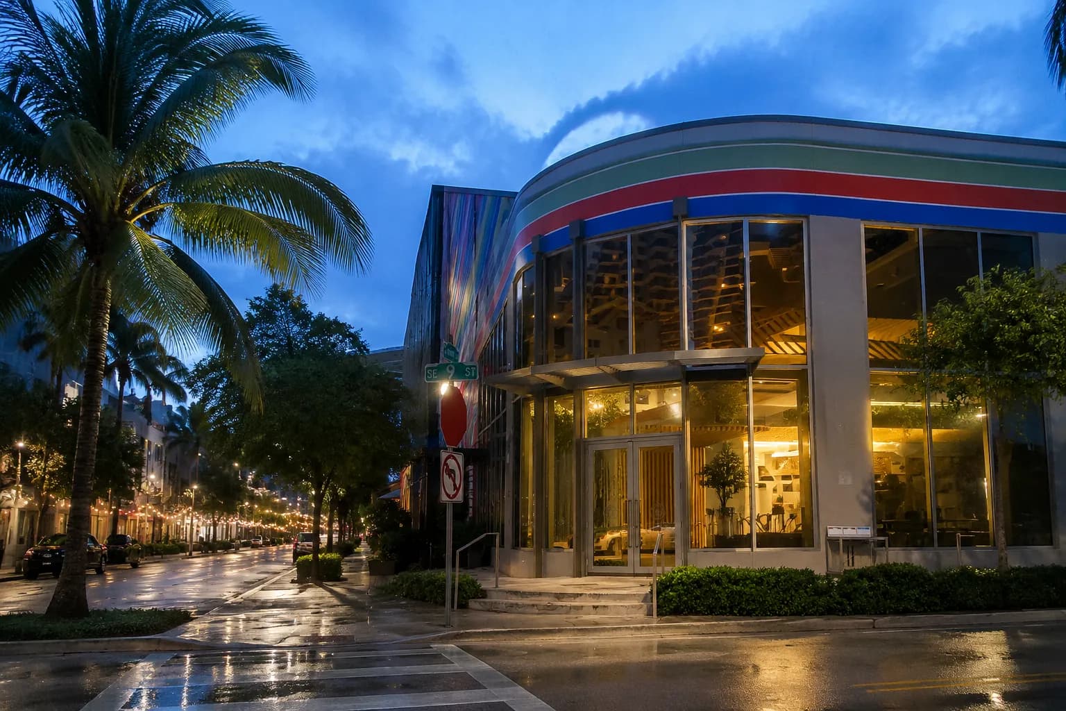 Street corner in Miami Design District at dusk with palm trees and wet sidewalk after rain