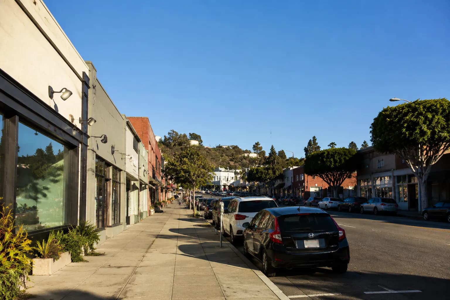 York Boulevard in Highland Park, Los Angeles, showing low-rise storefronts and street parking on a clear morning