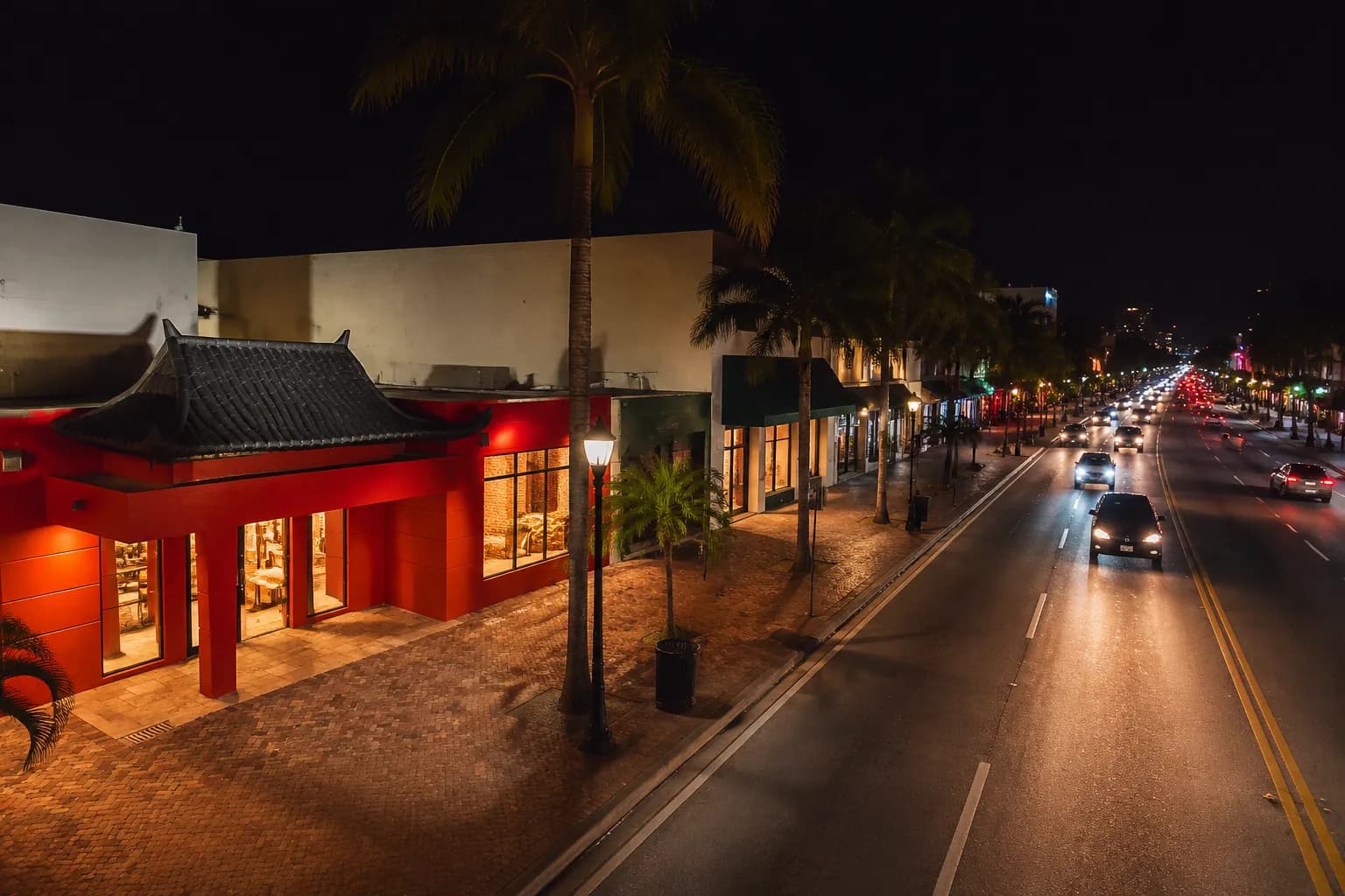 Calle Ocho street scene at night with lit storefronts and palm trees in Little Havana