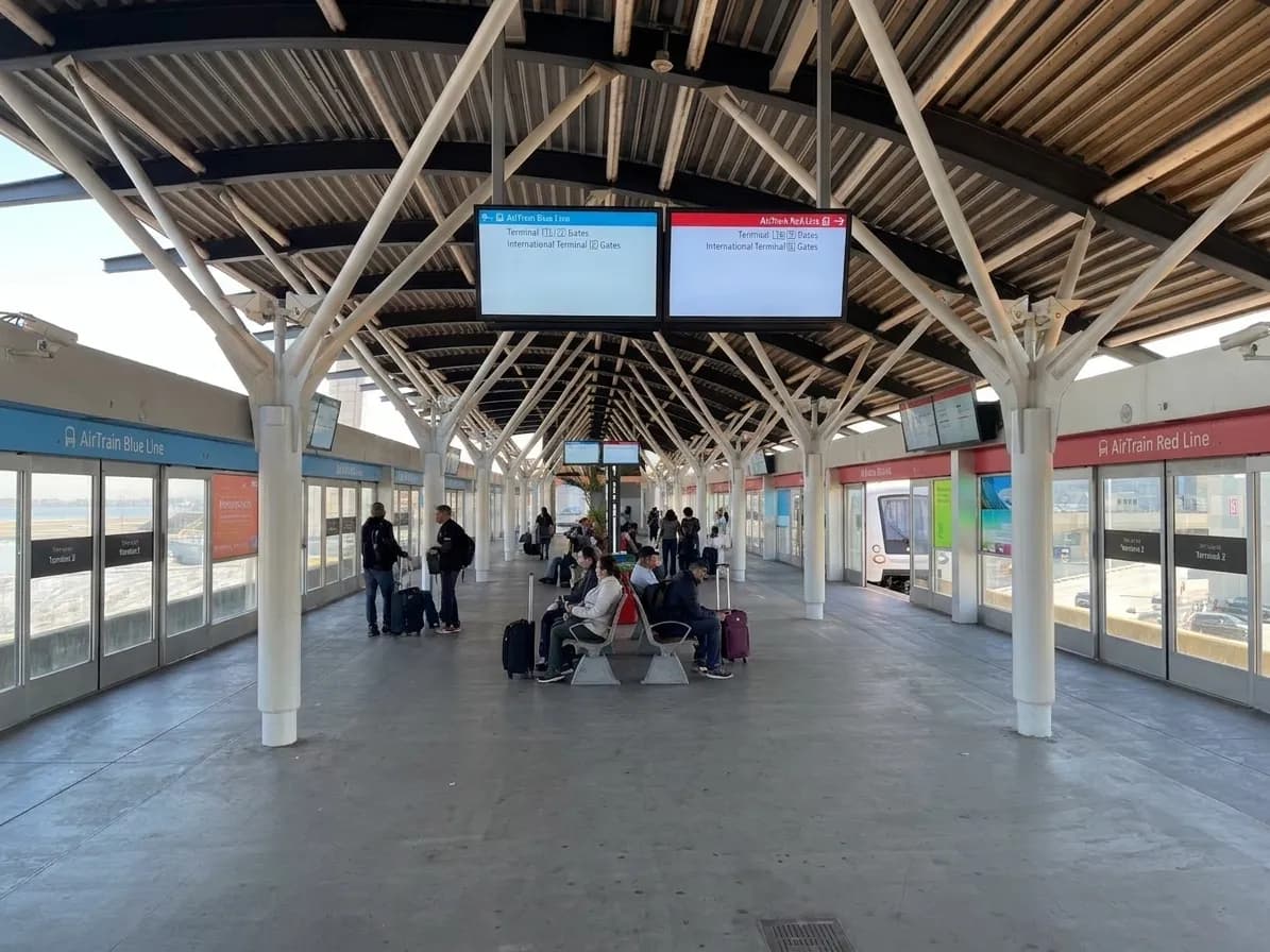 AirTrain platform at San Francisco International Airport showing automated train cars and route signage for terminal connections
