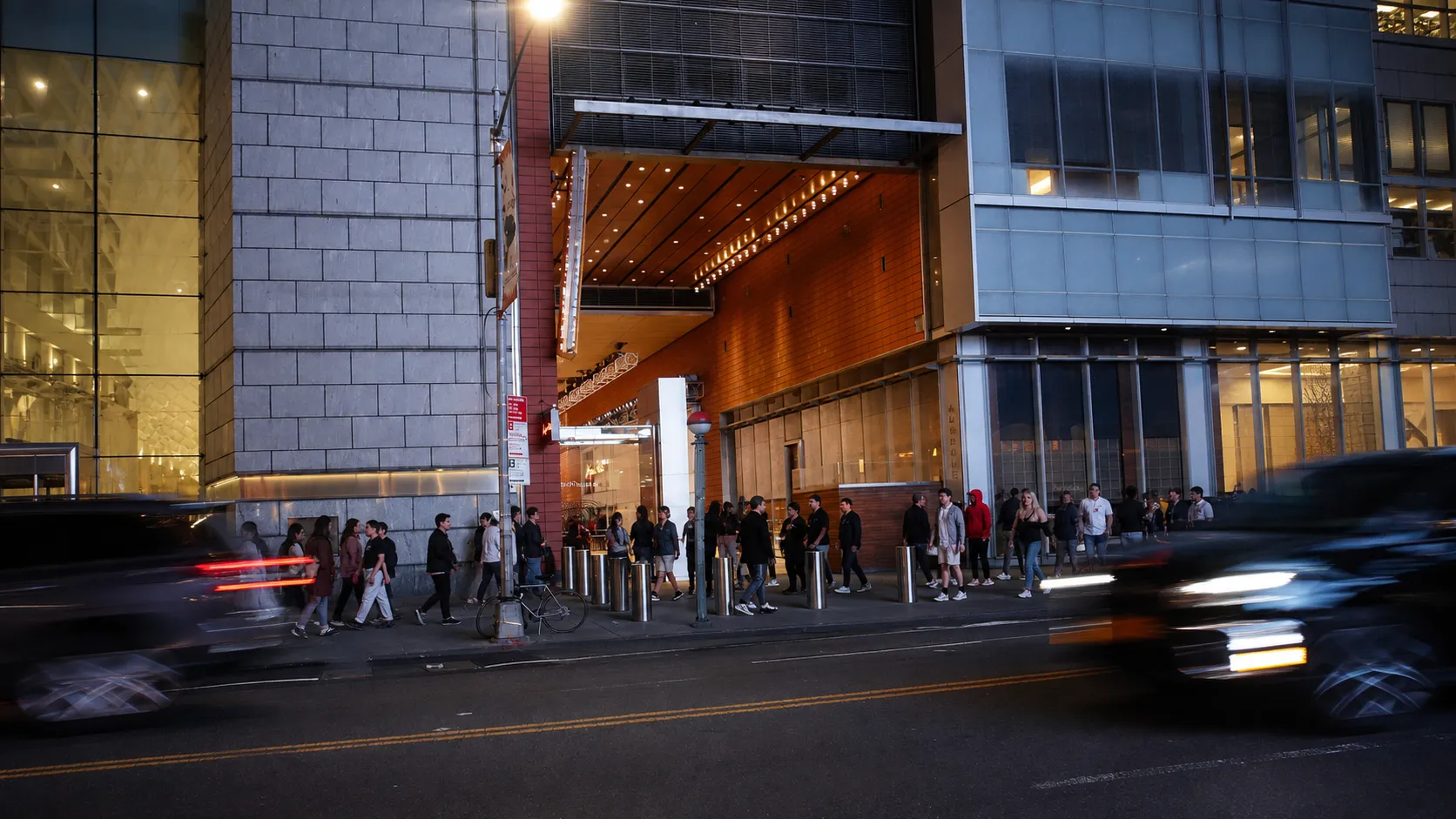 Commuters near a Times Square subway entrance at night before a television watch gathering.