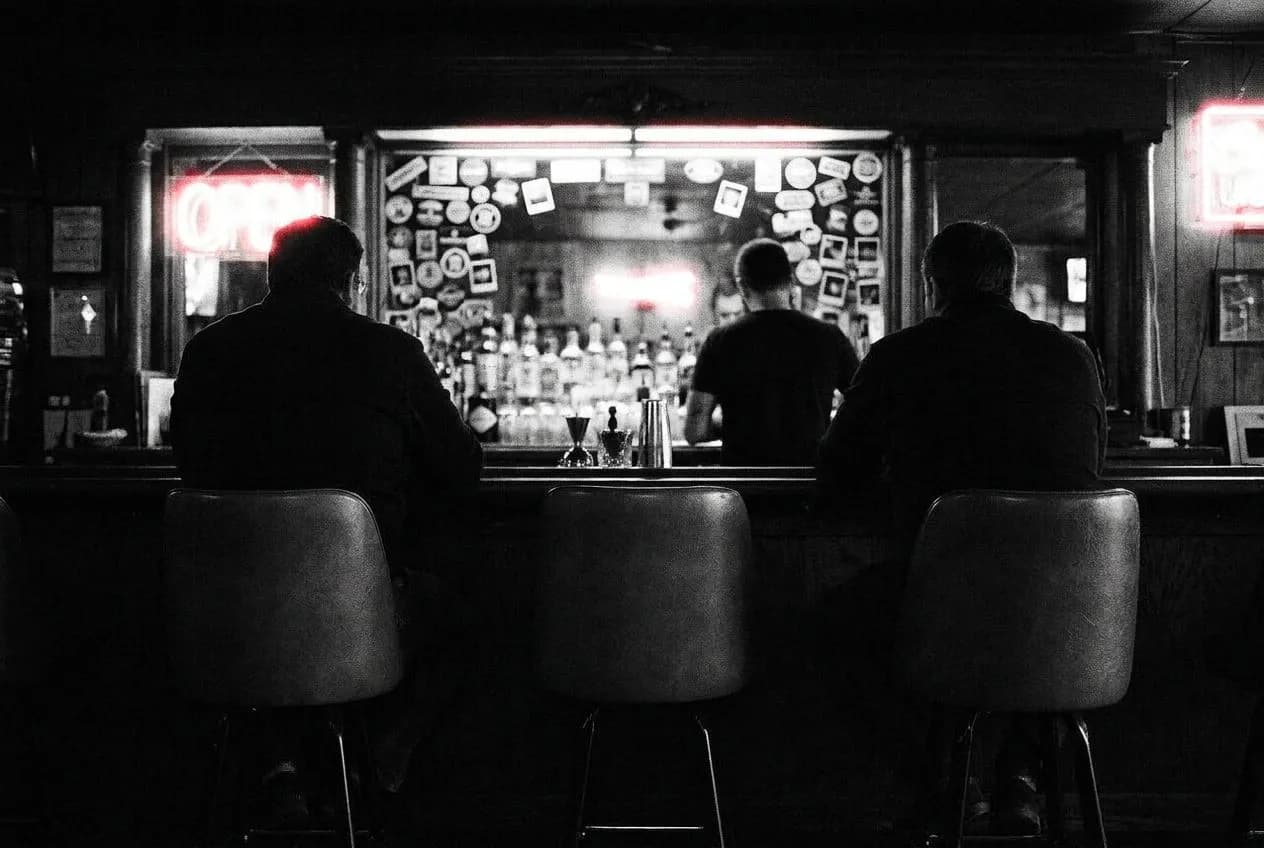 Bar seats at Holiday Cocktail Lounge where the neon sign still flickers in cursive