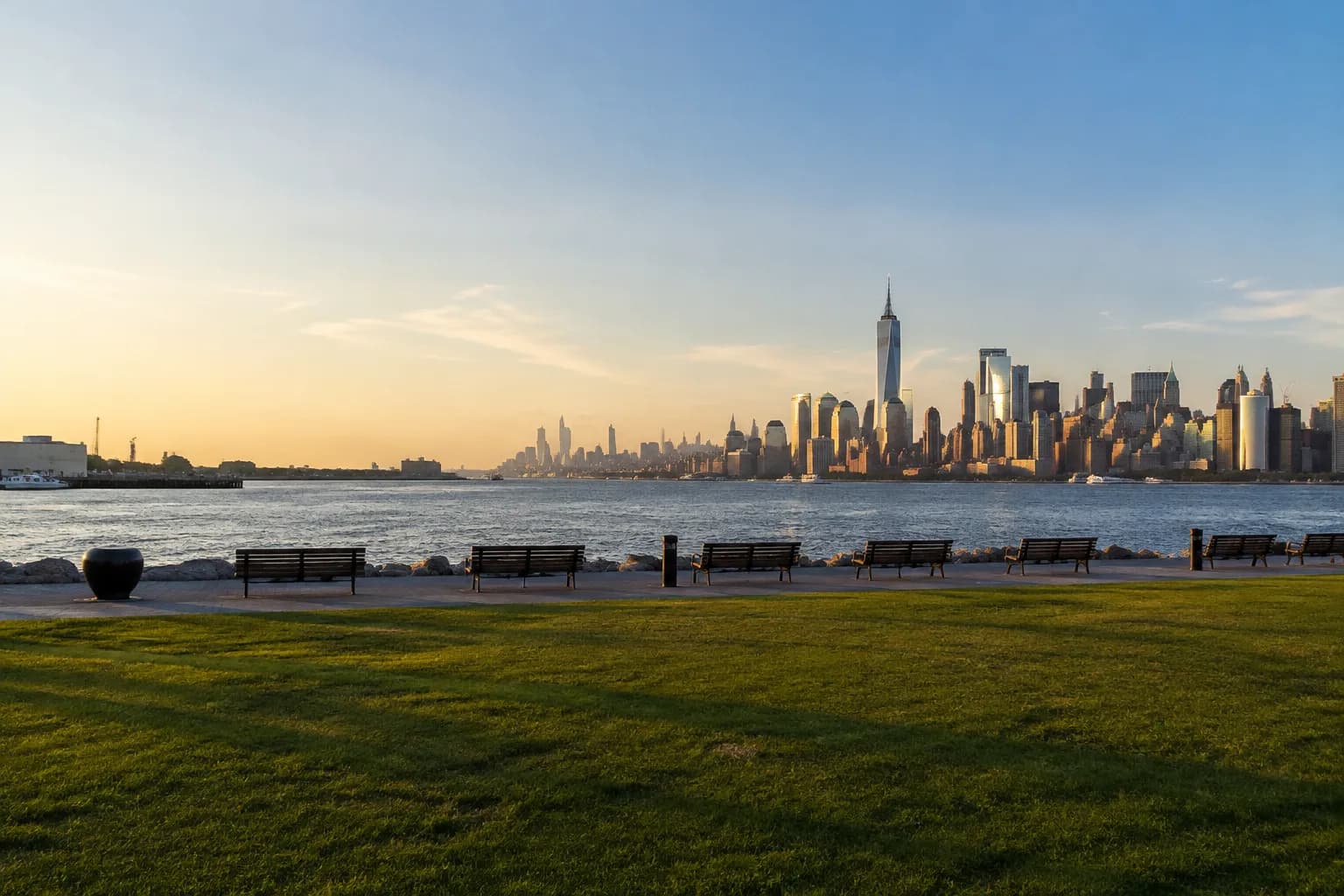 Transmitter Park waterfront in Greenpoint with Manhattan skyline across the East River at sunset