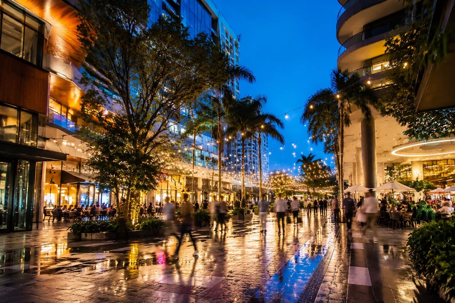 Mary Brickell Village plaza at dusk with pedestrians and storefront lights