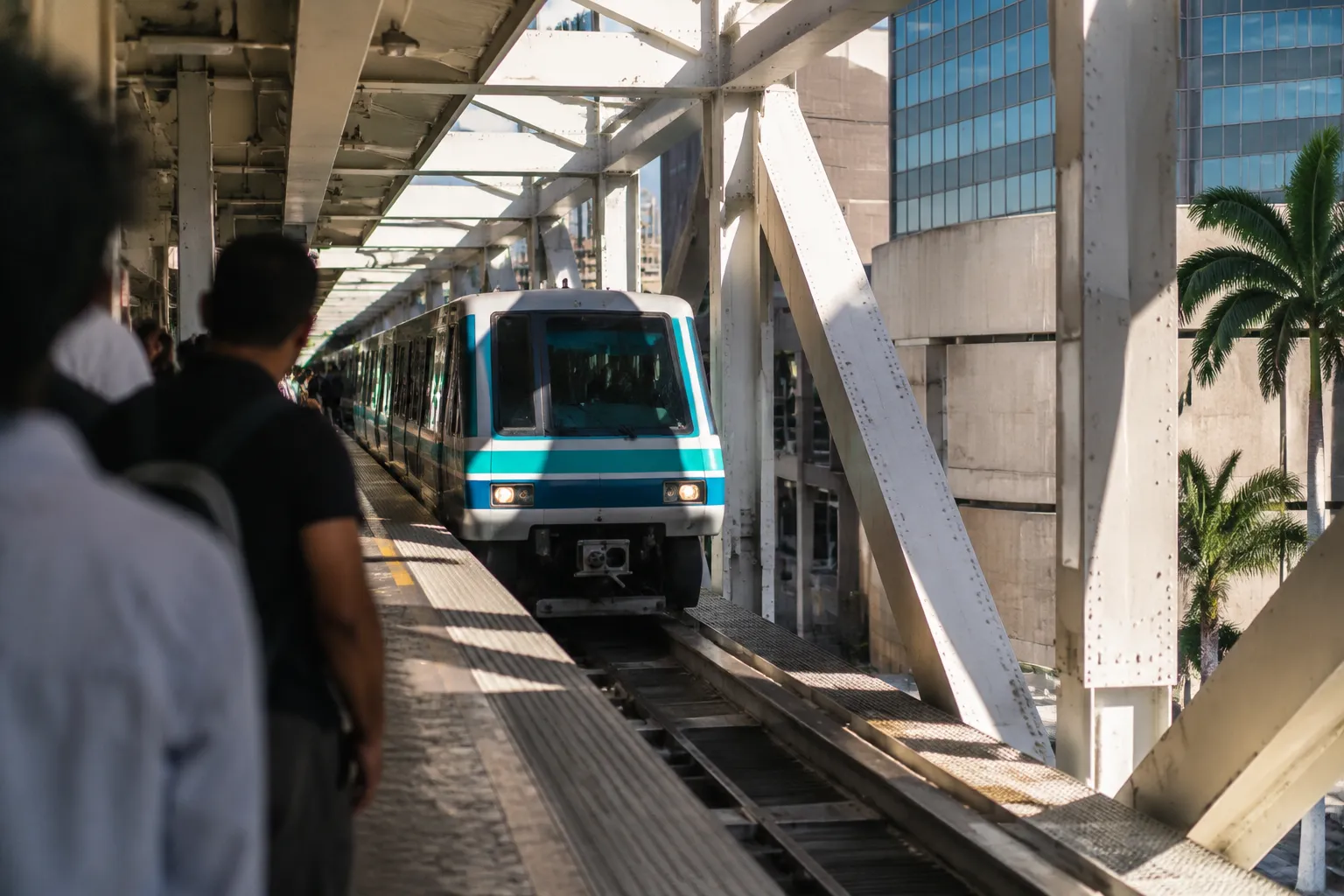 Metromover train arriving at Brickell station platform in midday sun