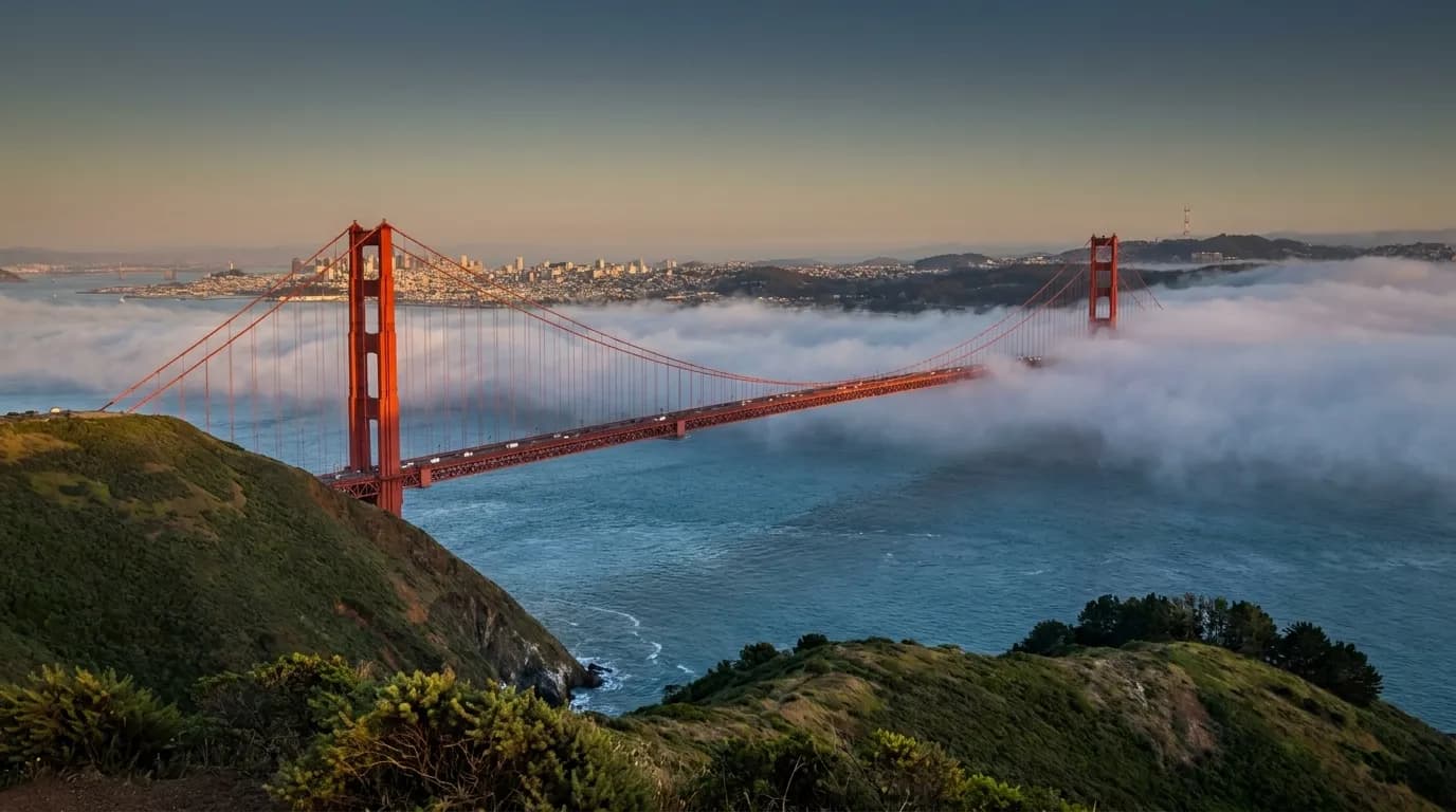Golden Gate Bridge and San Francisco skyline viewed from Marin Headlands at sunset with coastal fog