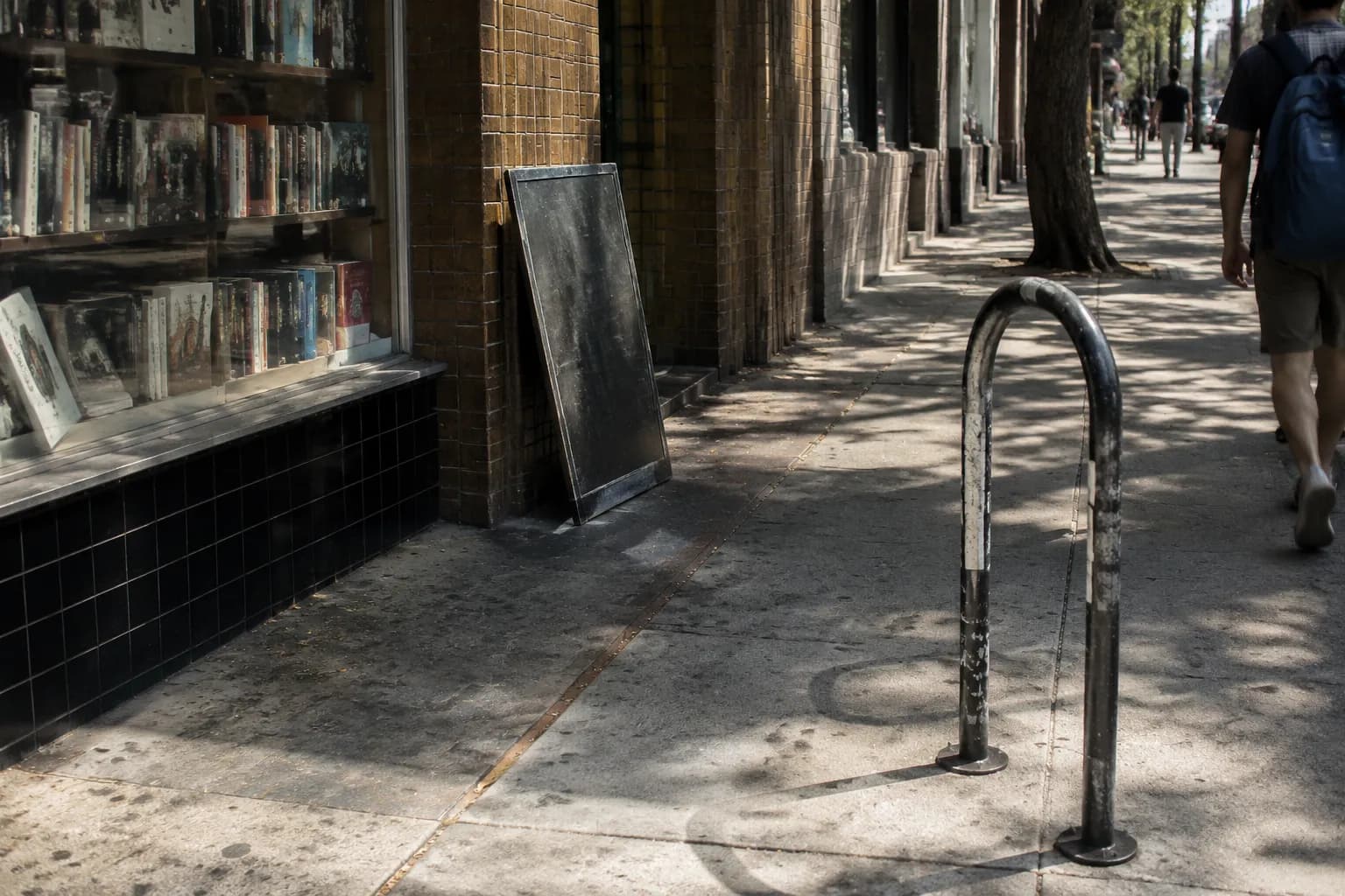 Telegraph Avenue sidewalk in Berkeley with bookstore window and bike rack in afternoon light