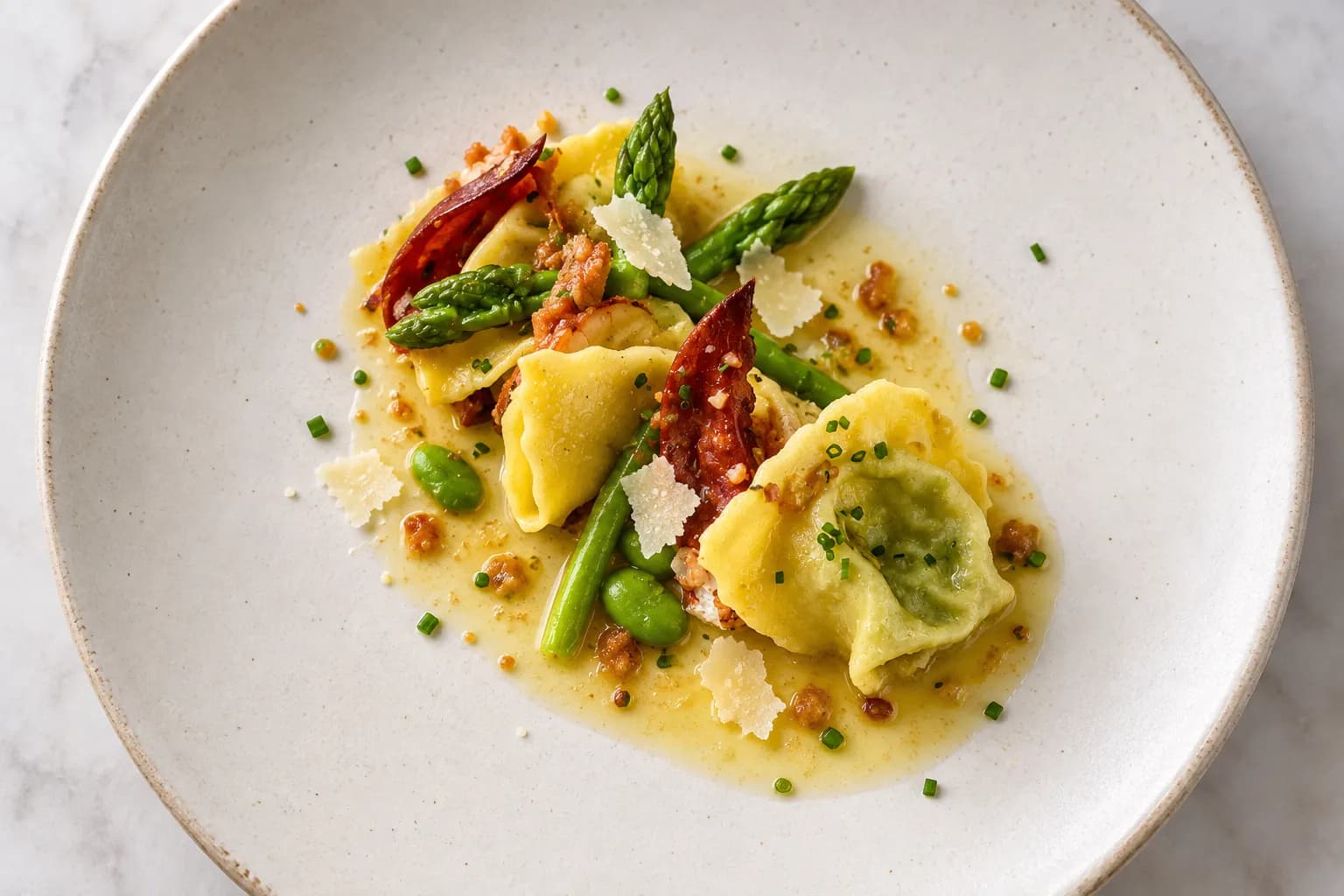 A handful of pinched filled pasta parcels on a wide pale plate with a thin butter sauce, shaved cheese and green herb, shot from overhead