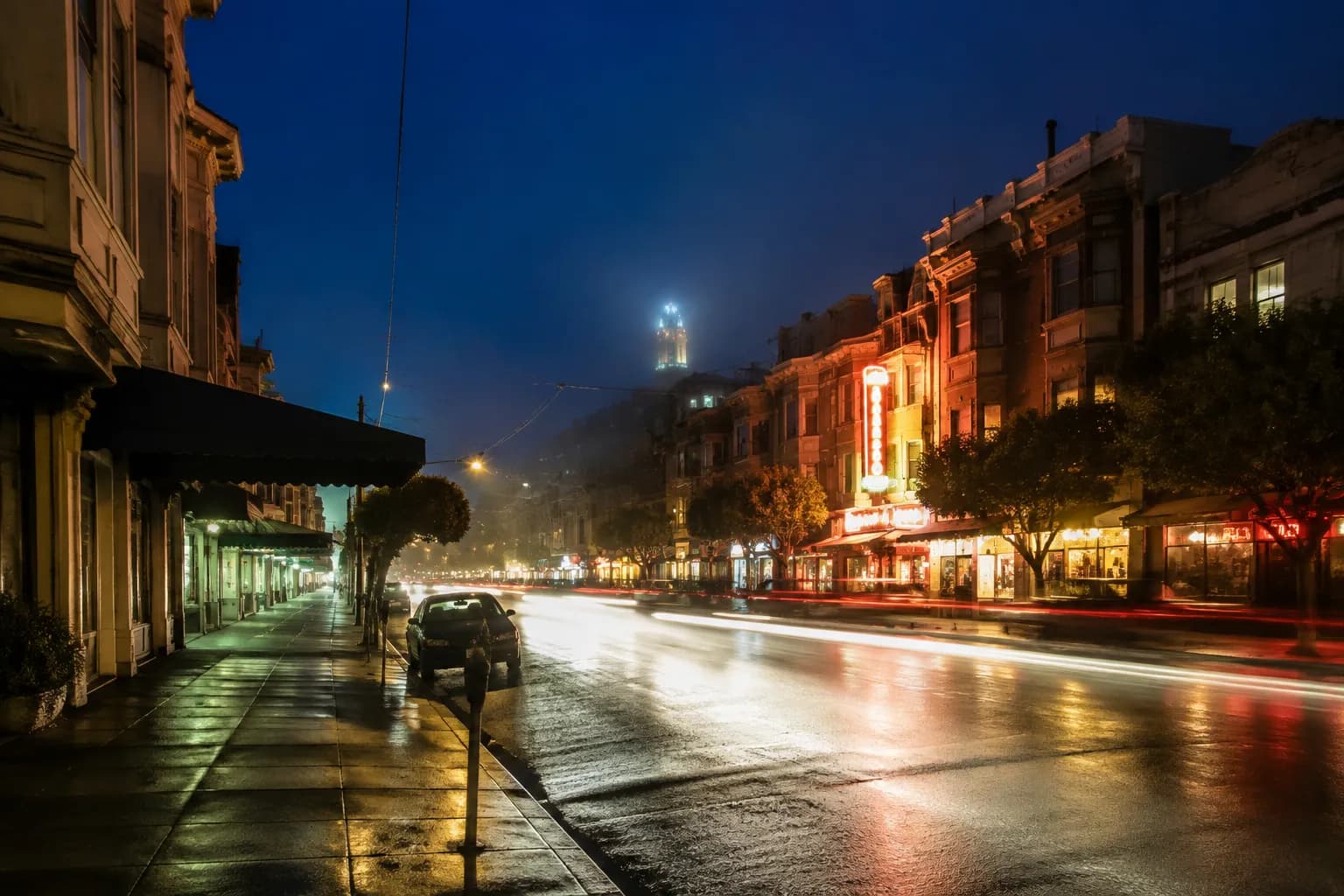Columbus Avenue in North Beach at night with neon signs and fog rolling in
