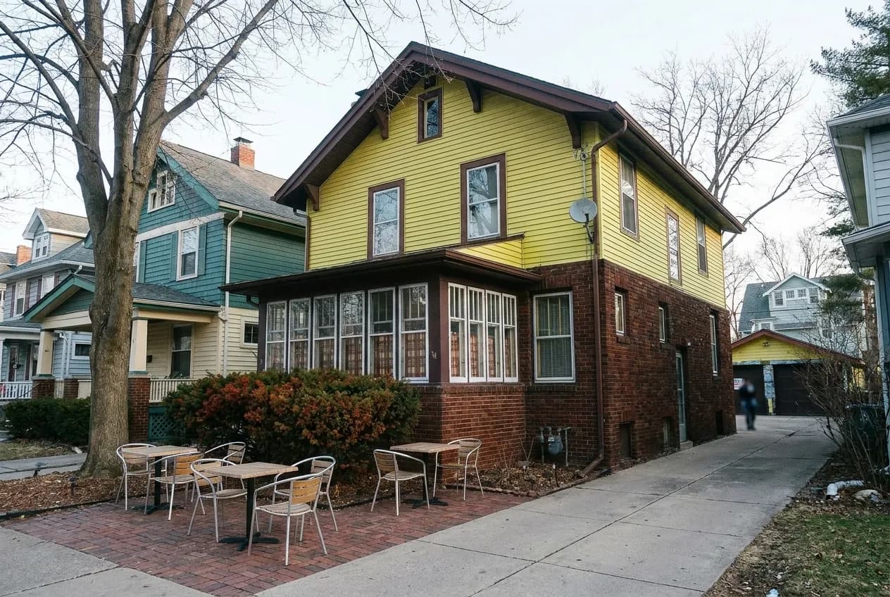 A yellow craftsman house converted into a cafe with a brick patio in Los Angeles morning light