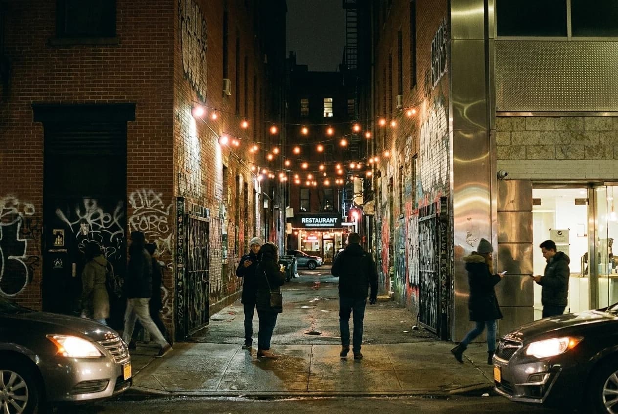 Freeman Alley entrance at dusk, narrow passageway with graffiti and dim lighting, Lower East Side