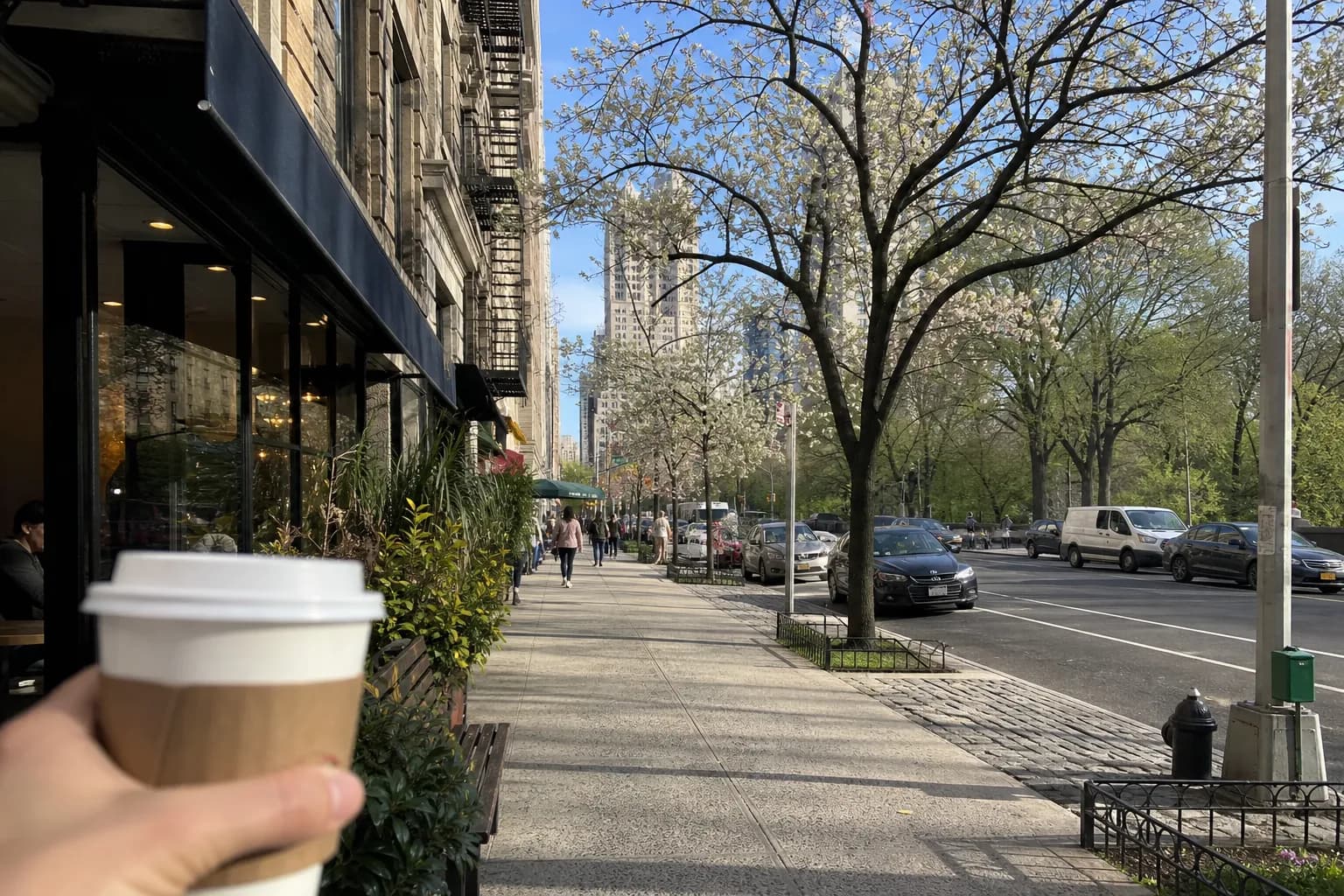 Coffee shop fronts along the edge of Central Park on a spring morning