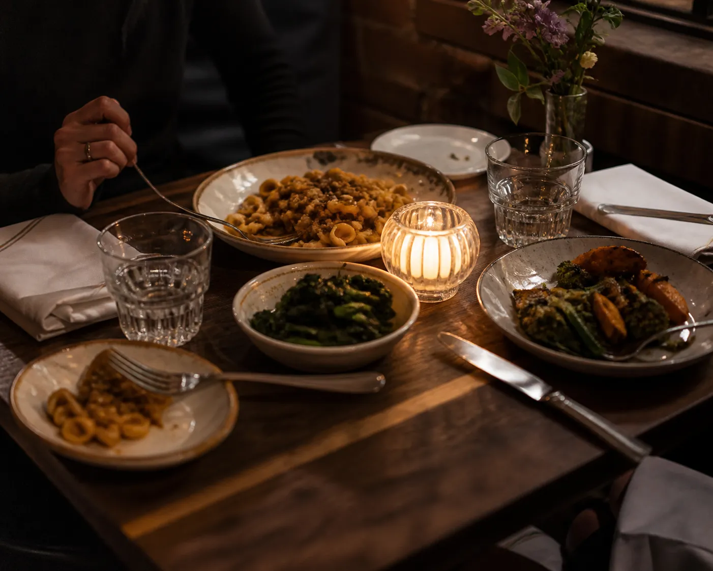 Elegant date-night dinner table with shared plates in a small NYC restaurant