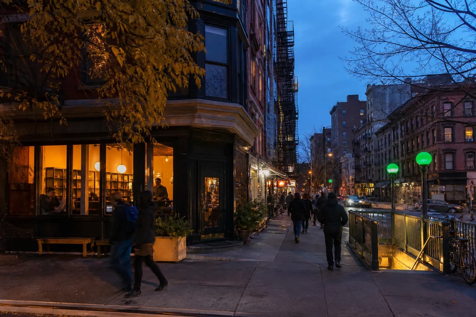 A Lower East Side block at dusk with cafe lights and a crisp fall street atmosphere.