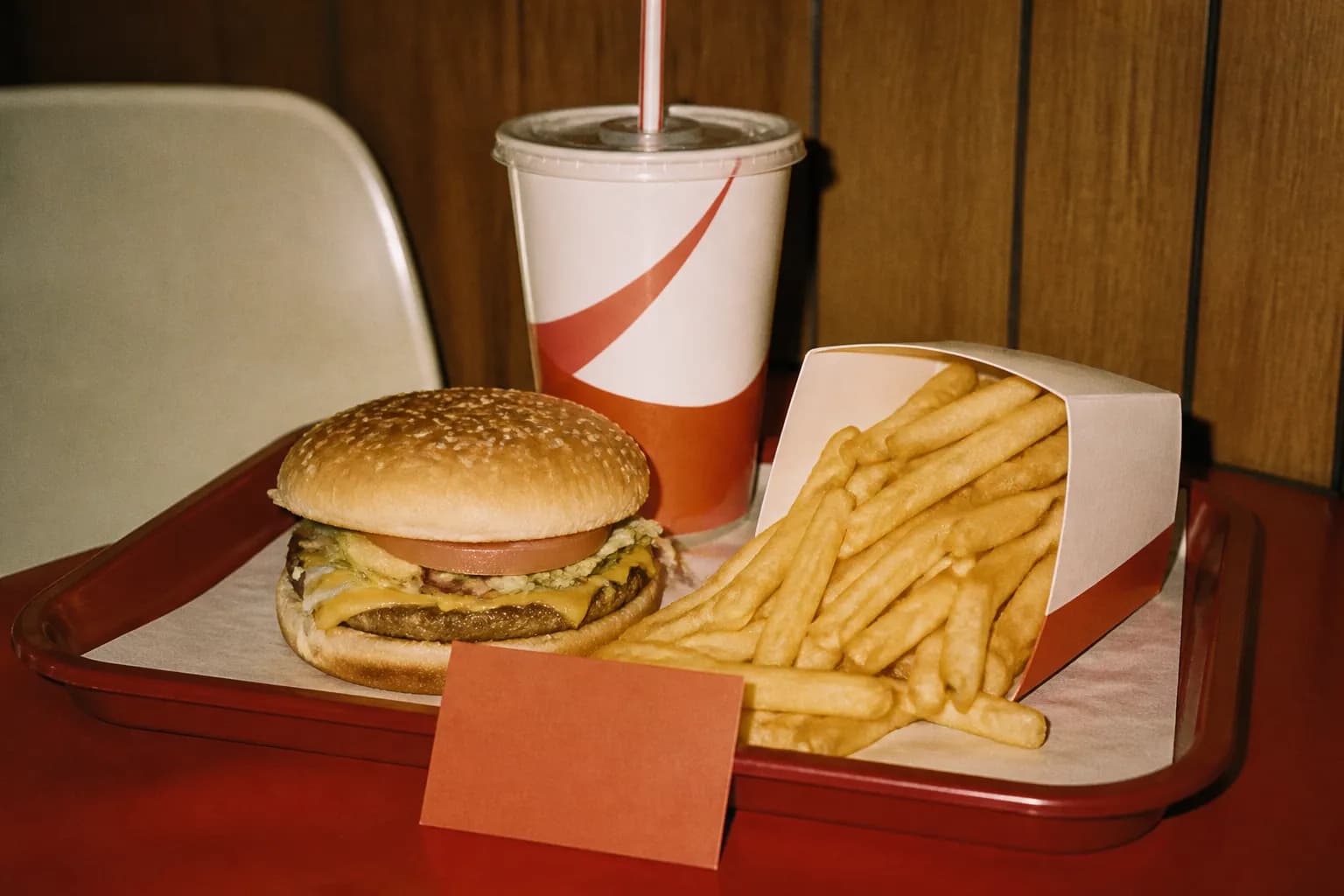 A fast food combo meal on a tray with a small paper deal tag beside it
