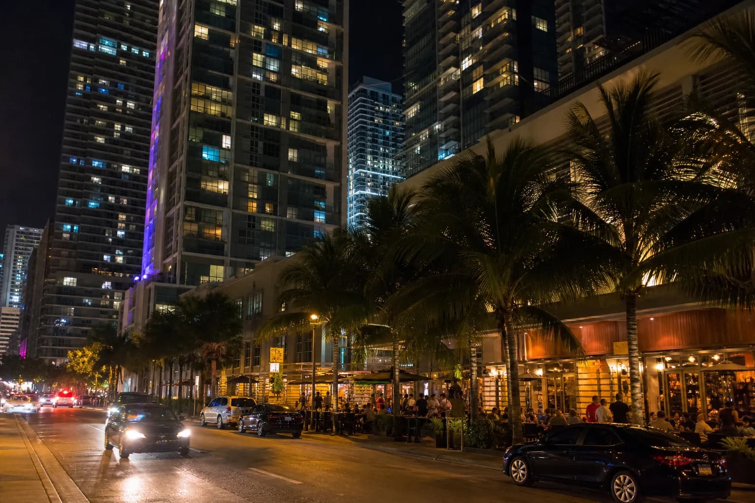 Brickell nightlife street with towers, palm trees, and evening restaurant glow
