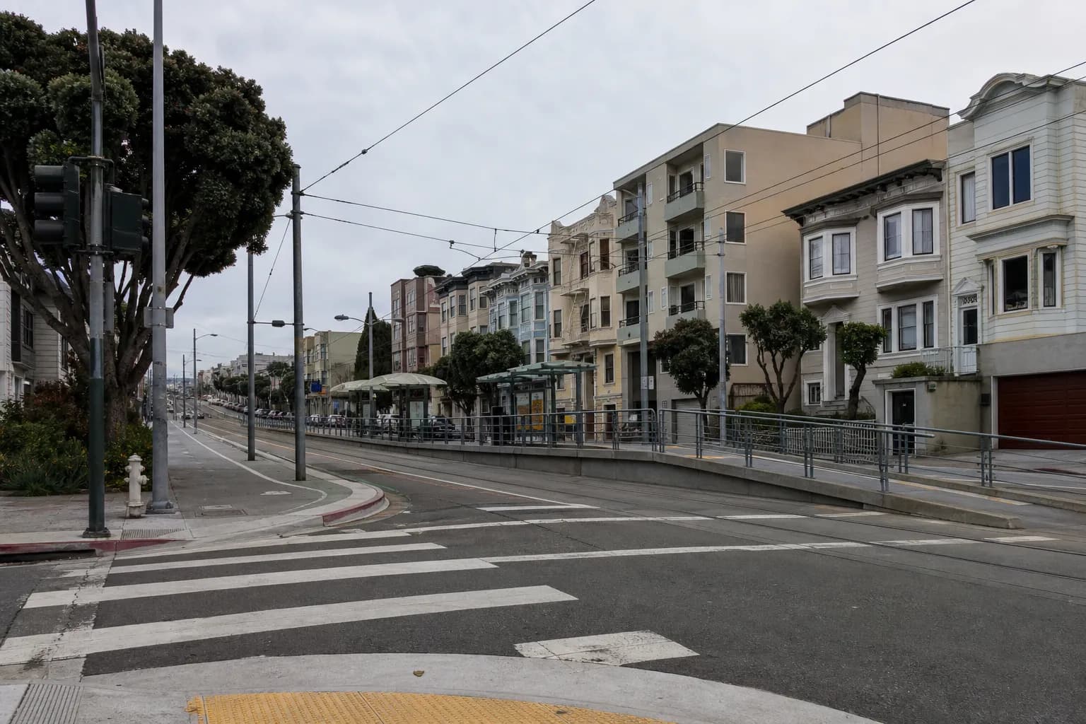 Residential San Francisco street with apartment buildings and a Muni line nearby