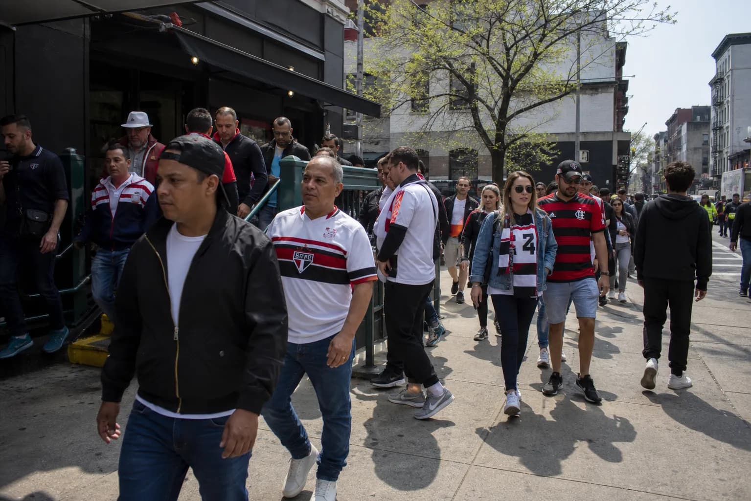 Commuters leaving a subway stop in a soccer-heavy neighborhood before brunch
