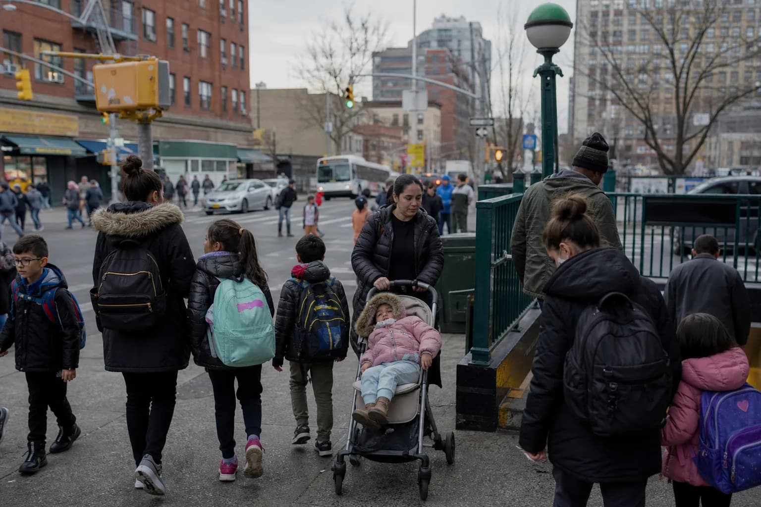 Subway entrance on a busy NYC family block with parents and kids heading home