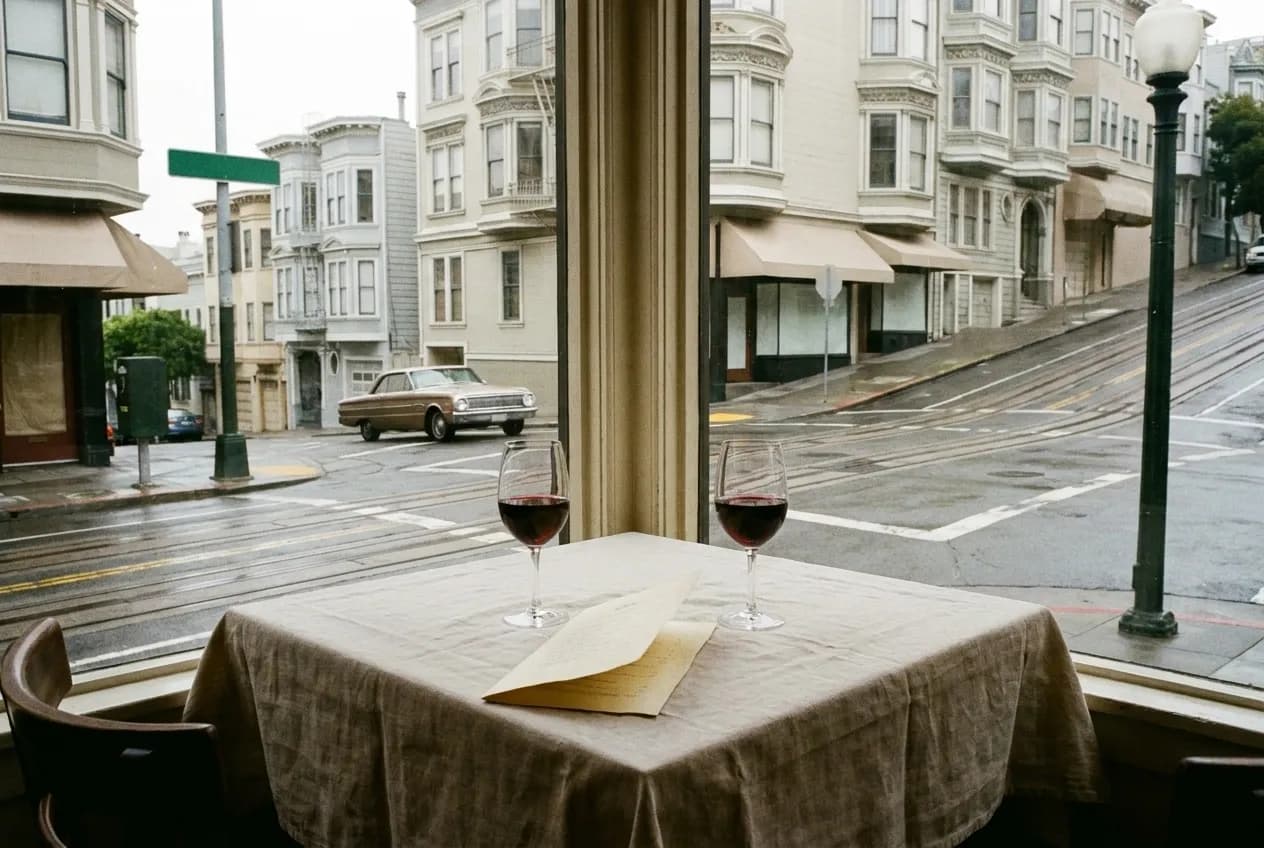 Two glasses of wine and a folded menu on a linen-covered corner table