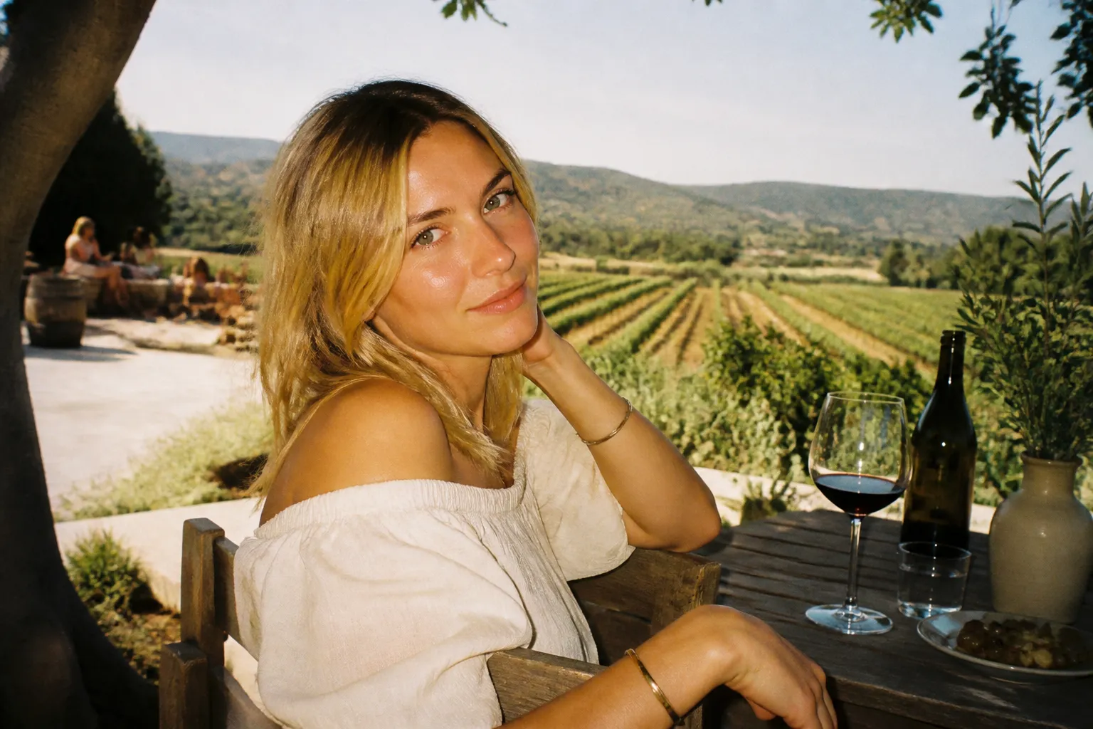 A scenic winery patio with tables overlooking green vineyards and distant hills