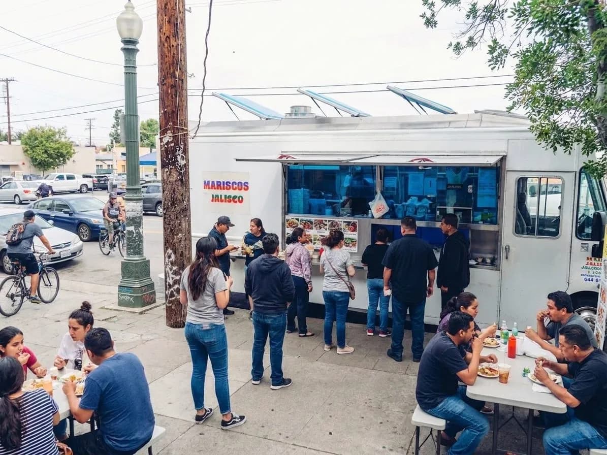 Street-level view of a Boyle Heights taco spot with people lining up for lunch