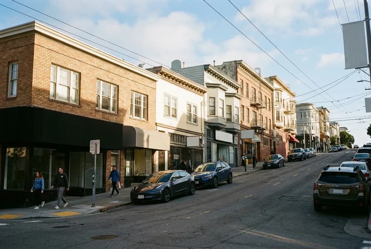 A small hilltop neighbourhood street in San Francisco in morning sun with low buildings
